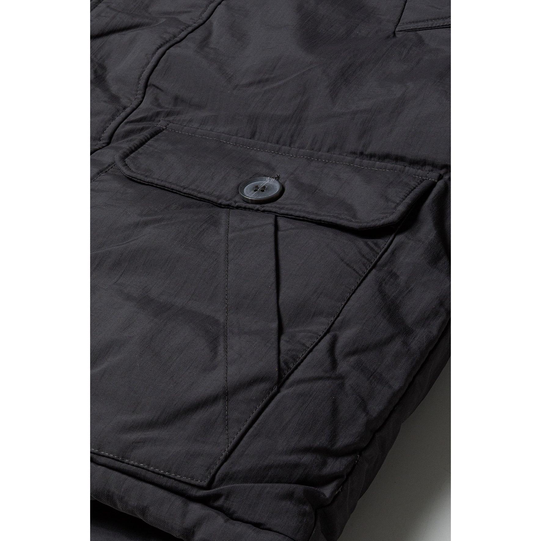 Close-up detail of dark grey parka jacket pocket with button closure showing fabric texture and construction quality