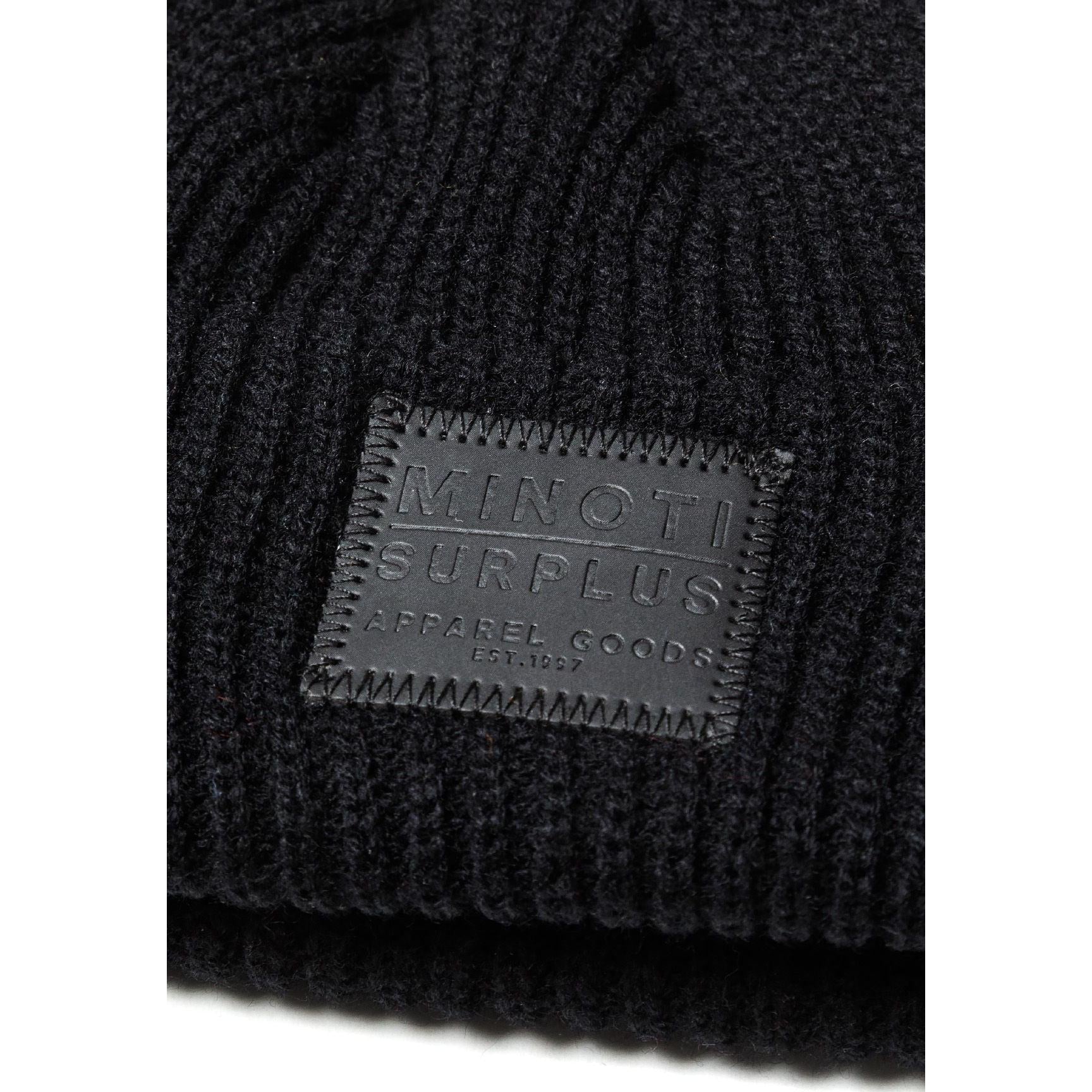 Detail view of burgundy beanie folded to show the ribbed knit texture and Minoti Surplus rectangular patch label with embossed lettering on the front
