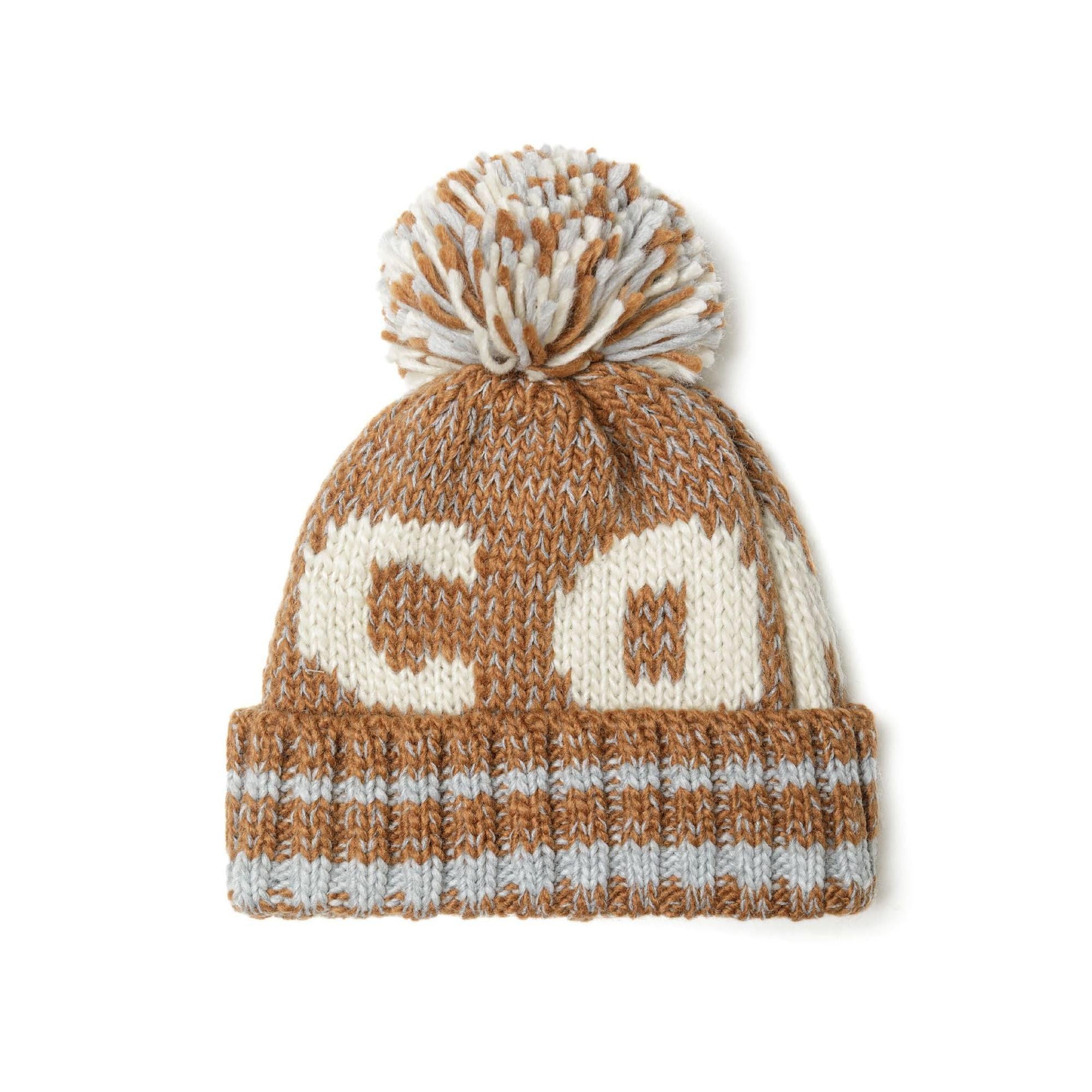 Beige jacquard knit beanie with cream pattern and multicoloured pom pom on white background, front view