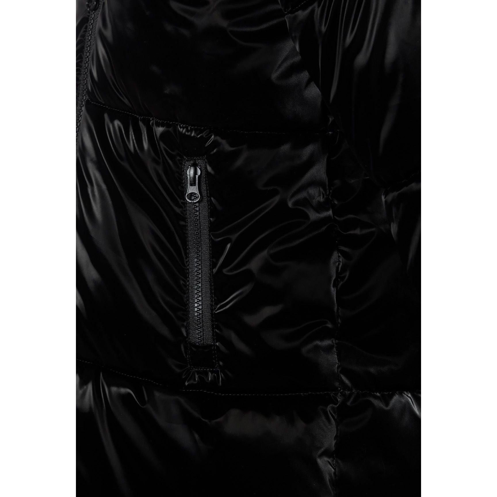 Close-up detail of circular embroidered patch on black jacket sleeve featuring heart design with text around border