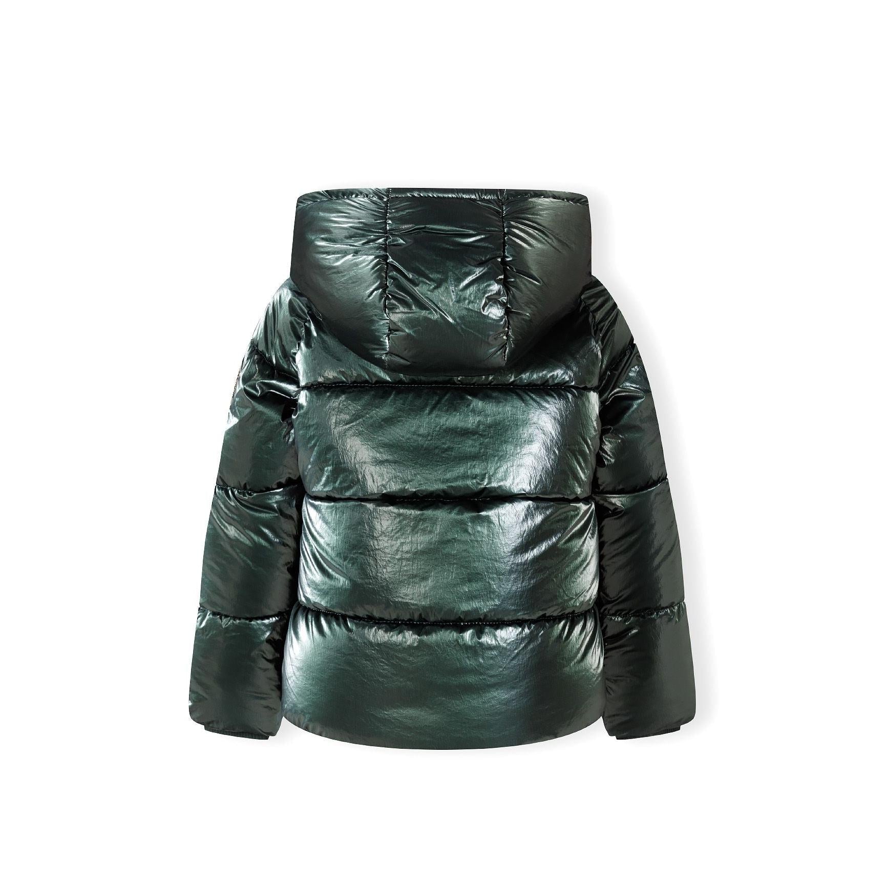 Close-up detail of embroidered circular patch with heart design and text on green metallic jacket fabric