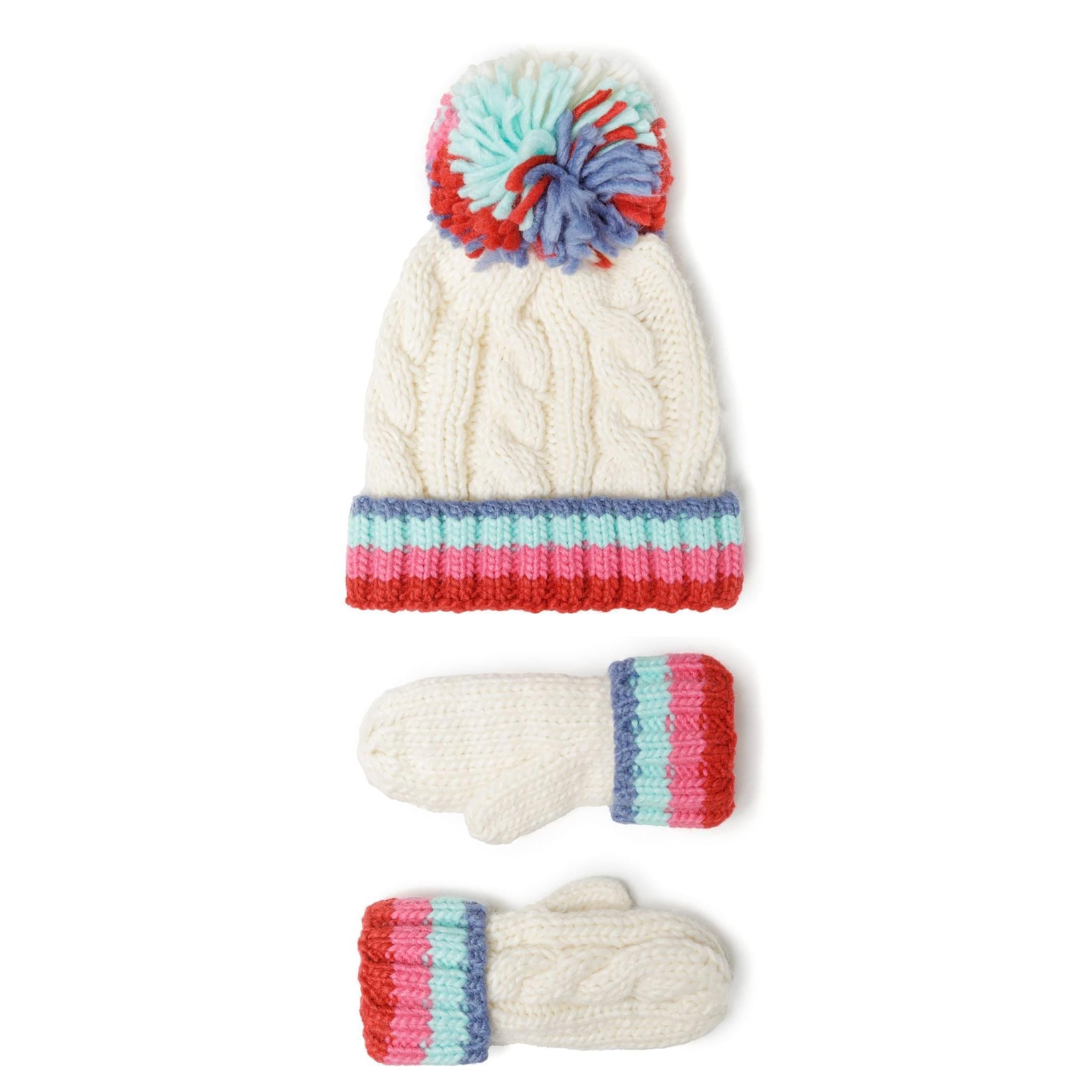 Cable knit hat and mittens set in cream with rainbow striped cuffs and colourful pom pom on white background