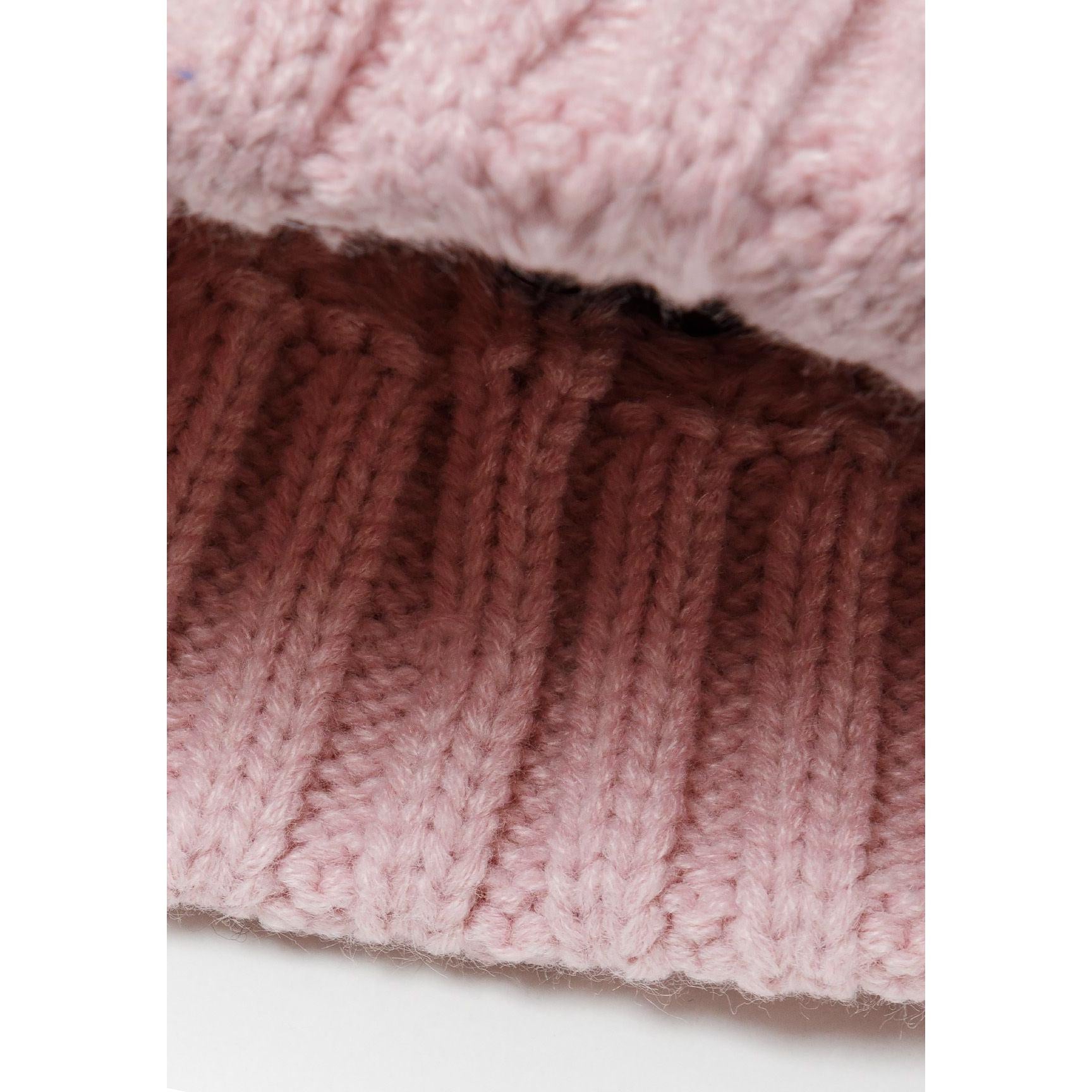 Interior view of light pink cable knit hat showing ribbed band construction and soft lining