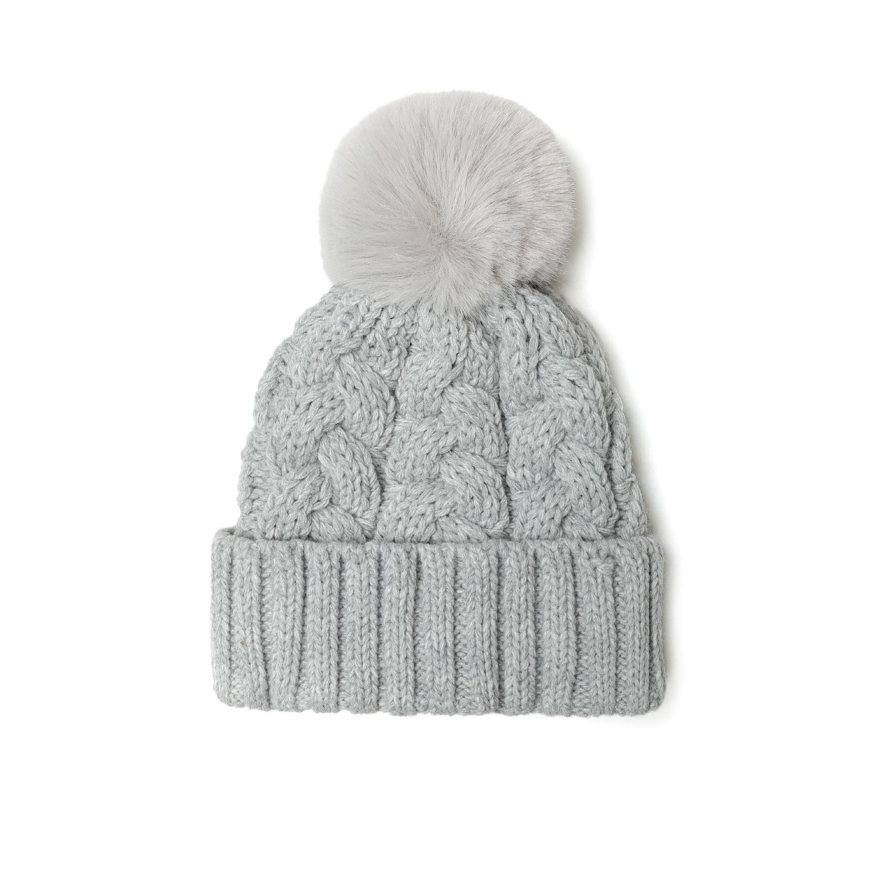 Grey cable knit beanie with fluffy pom pom shown against white background, displaying classic cable pattern texture and ribbed cuff detail