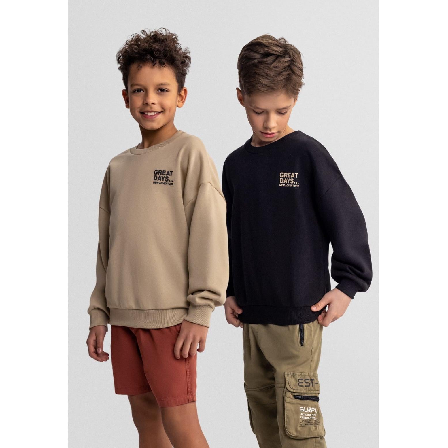 Two boys wearing Great Days adventure sweatshirts - one in beige, one in black, styled with casual bottoms against white studio background