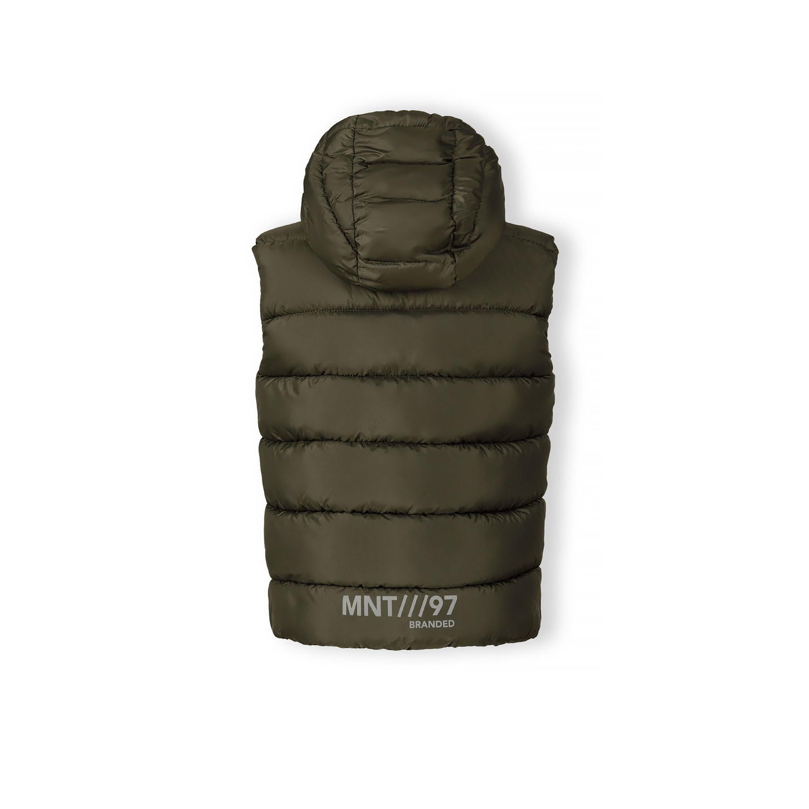 Close-up detail of black circular logo patch on khaki padded fabric with quilted stitching pattern