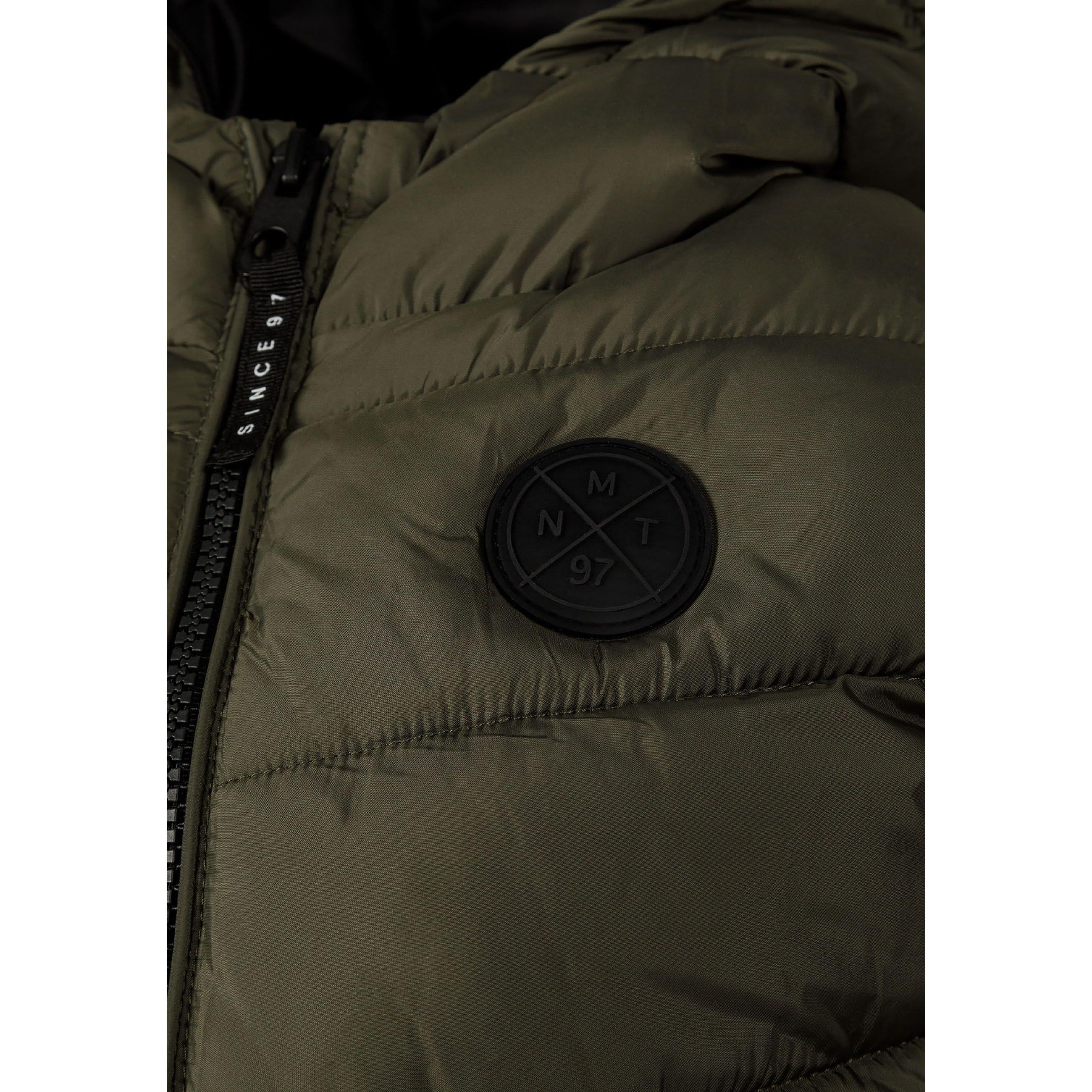 Close-up detail of black circular logo patch on khaki padded fabric with quilted stitching pattern