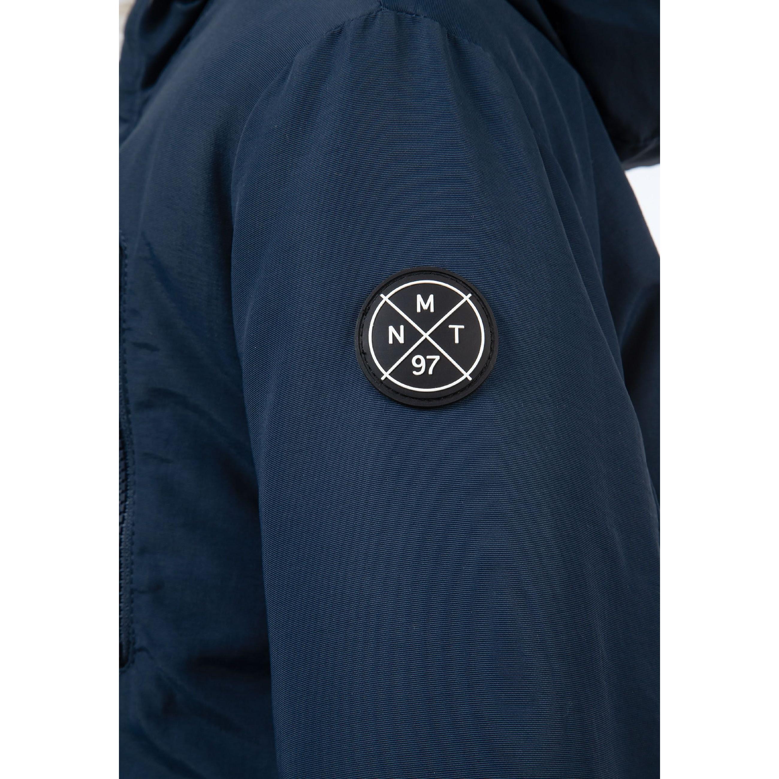 Close-up detail of navy parka pocket with button closure and red accent tab showing fabric texture