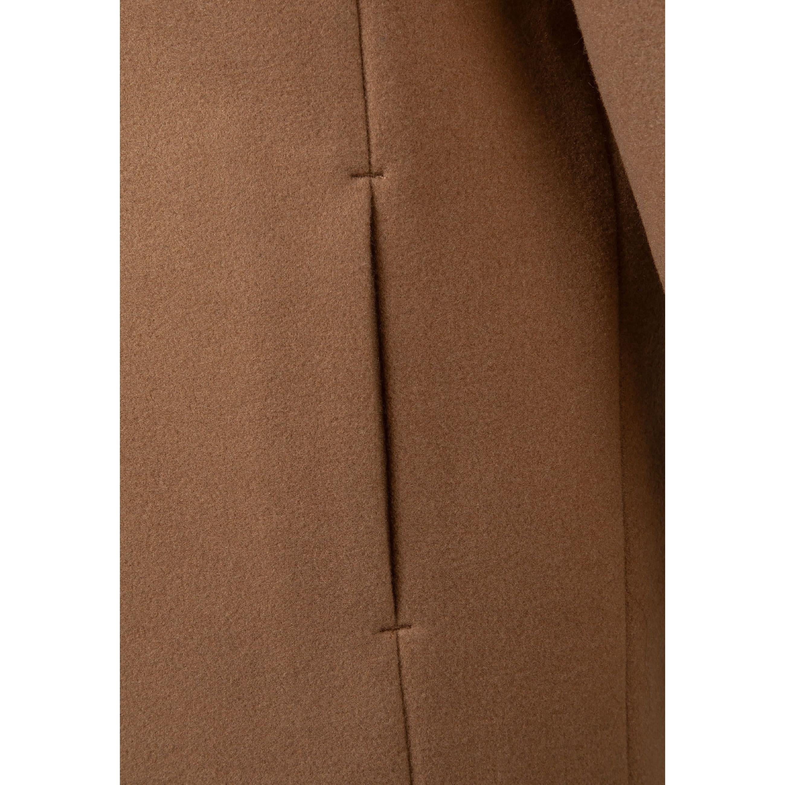 Close-up detail of beige coat fabric showing hidden seam pocket construction and smooth texture