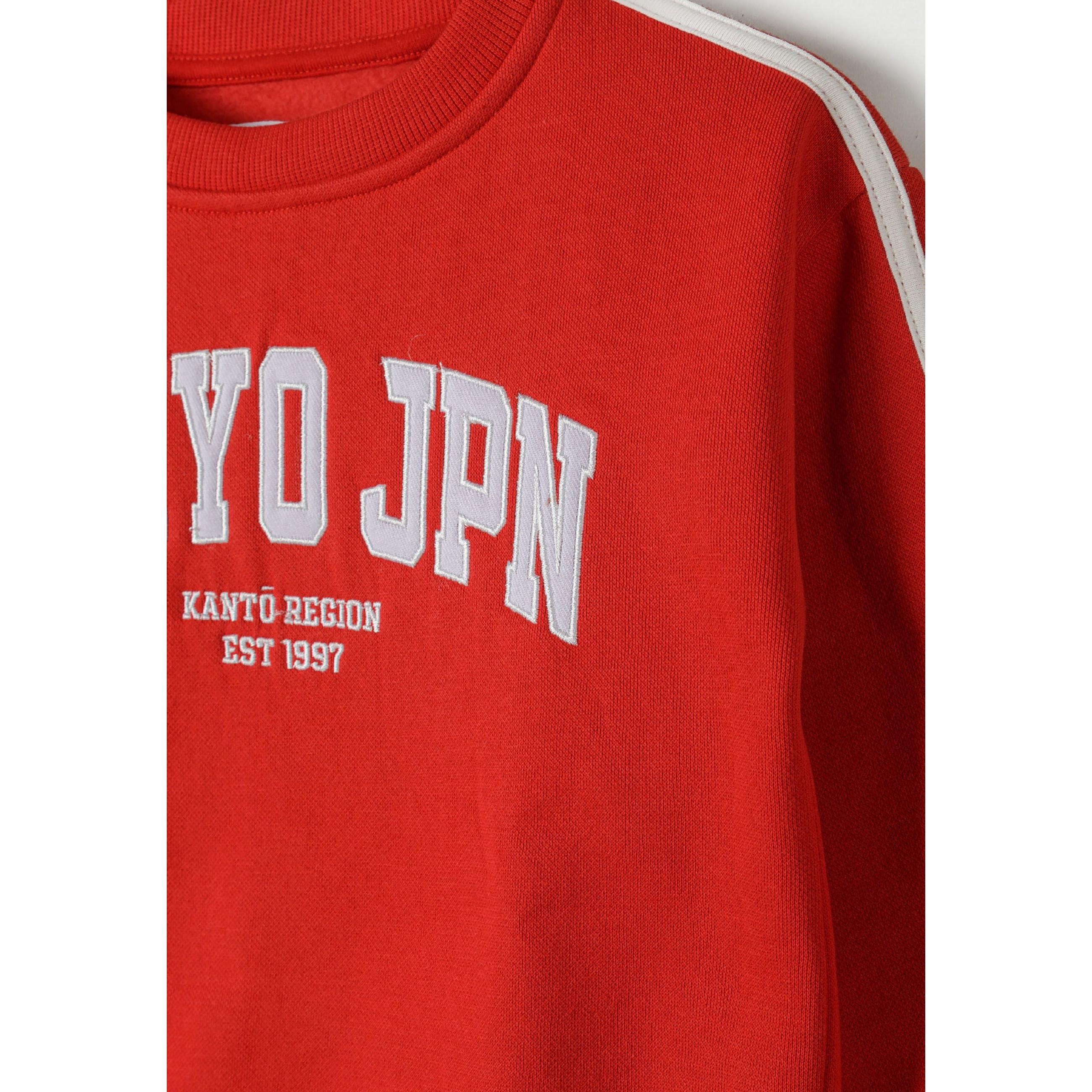 Close-up detail of red joggers showing white drawstring ties and front pocket construction