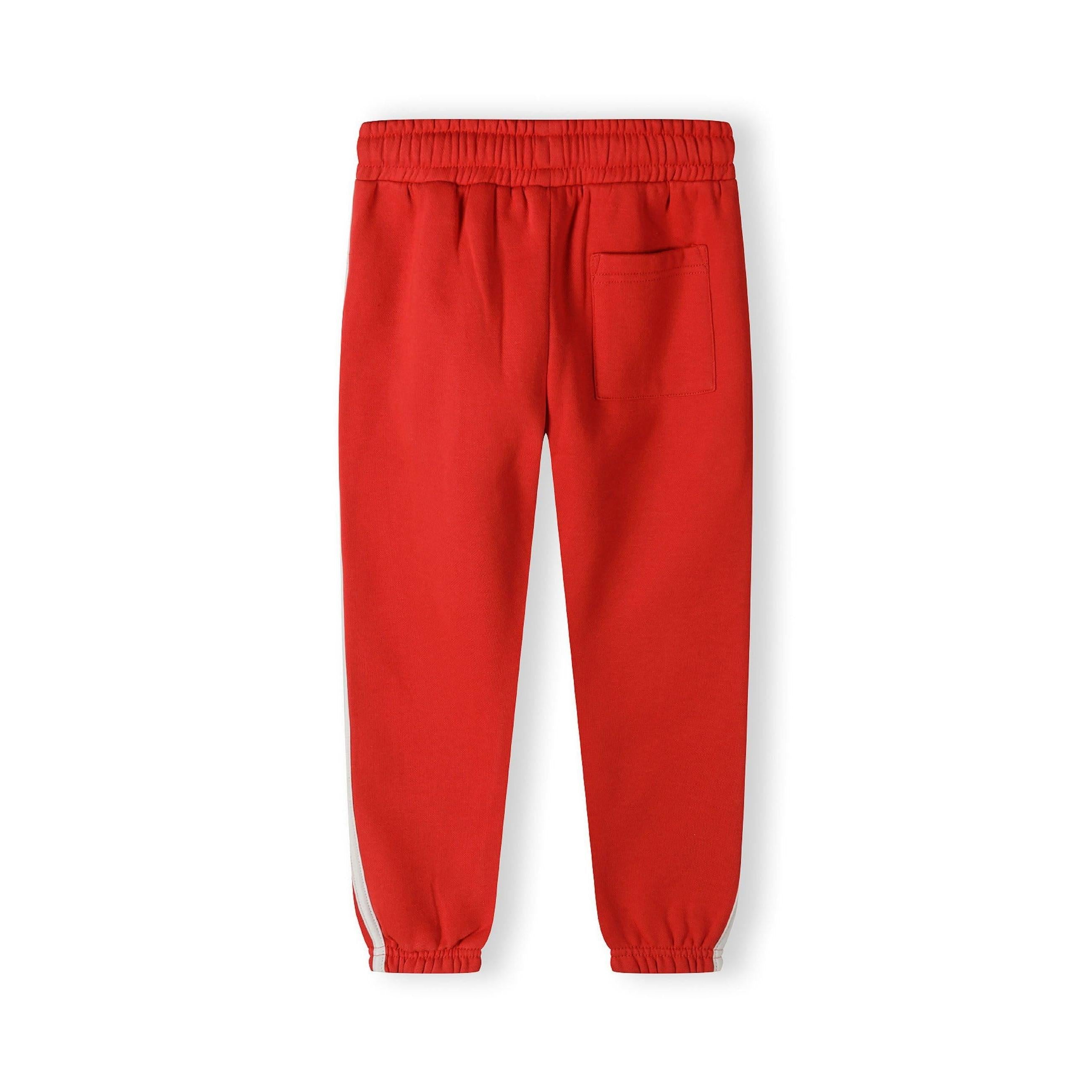 Close-up detail of red joggers showing white drawstring ties and front pocket construction