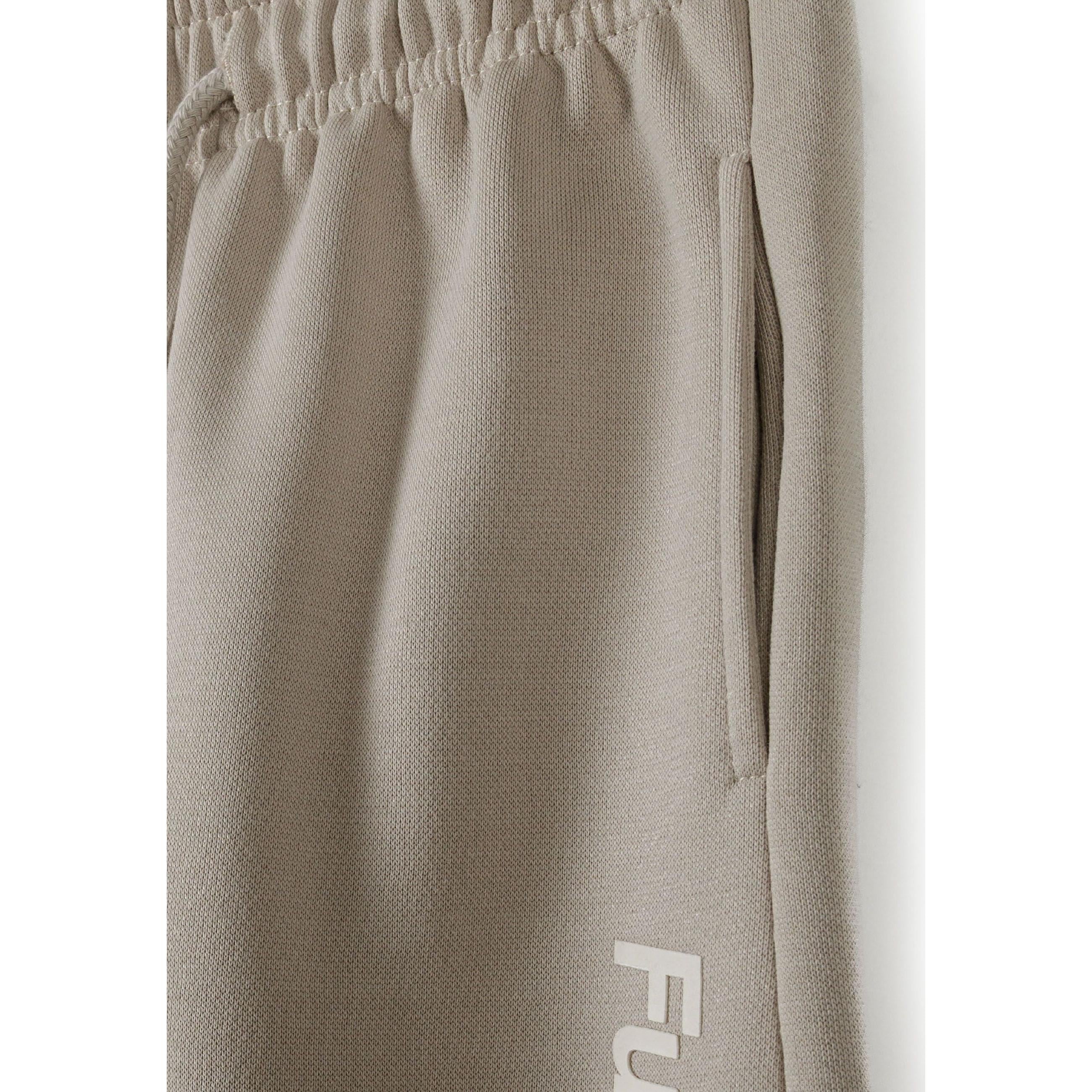 Close-up detail of grey joggers showing elastic waistband with drawstring, side pocket and Future Skate text print along the leg seam