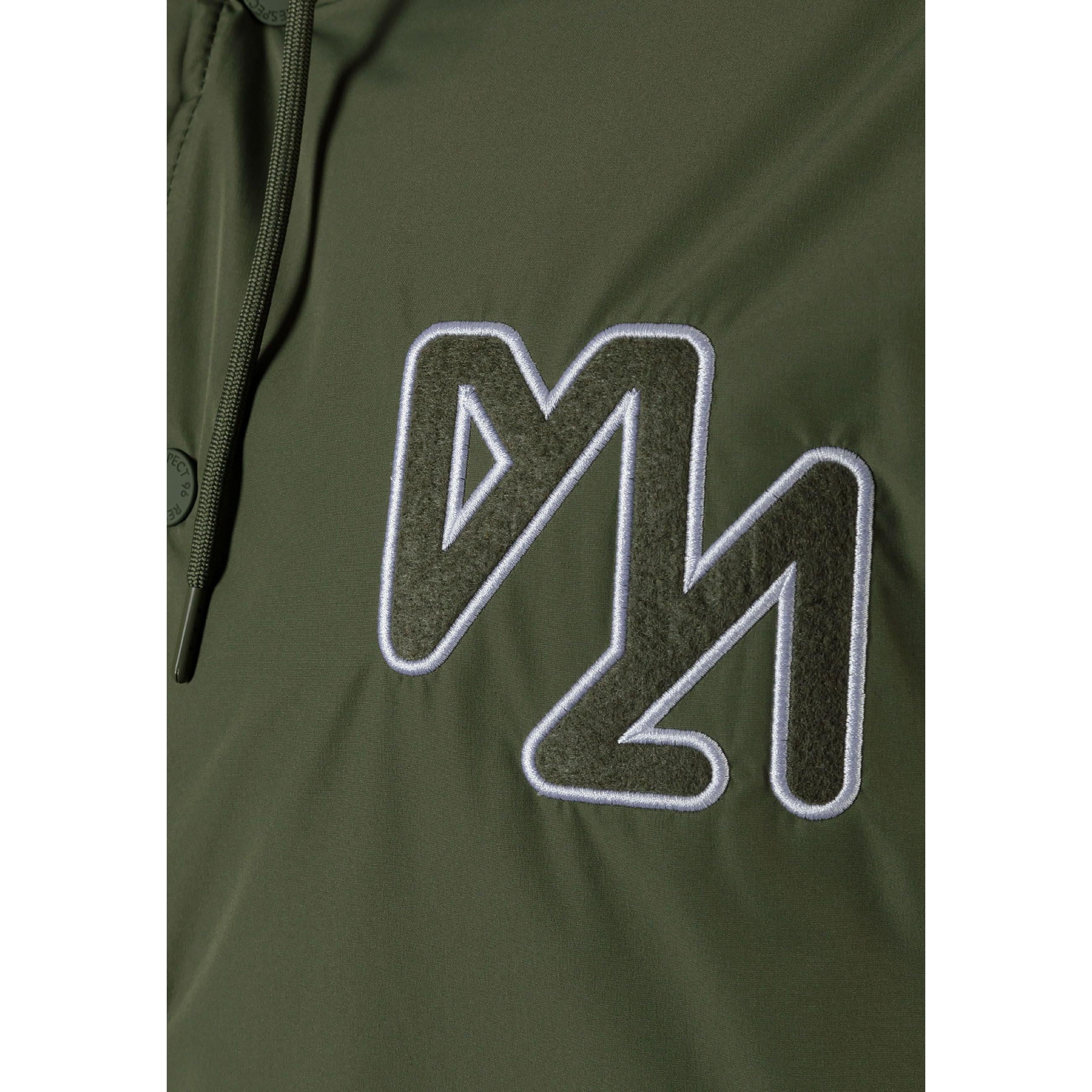 Close-up detail of khaki jacket showing zip pocket, button closure and ribbed trim construction