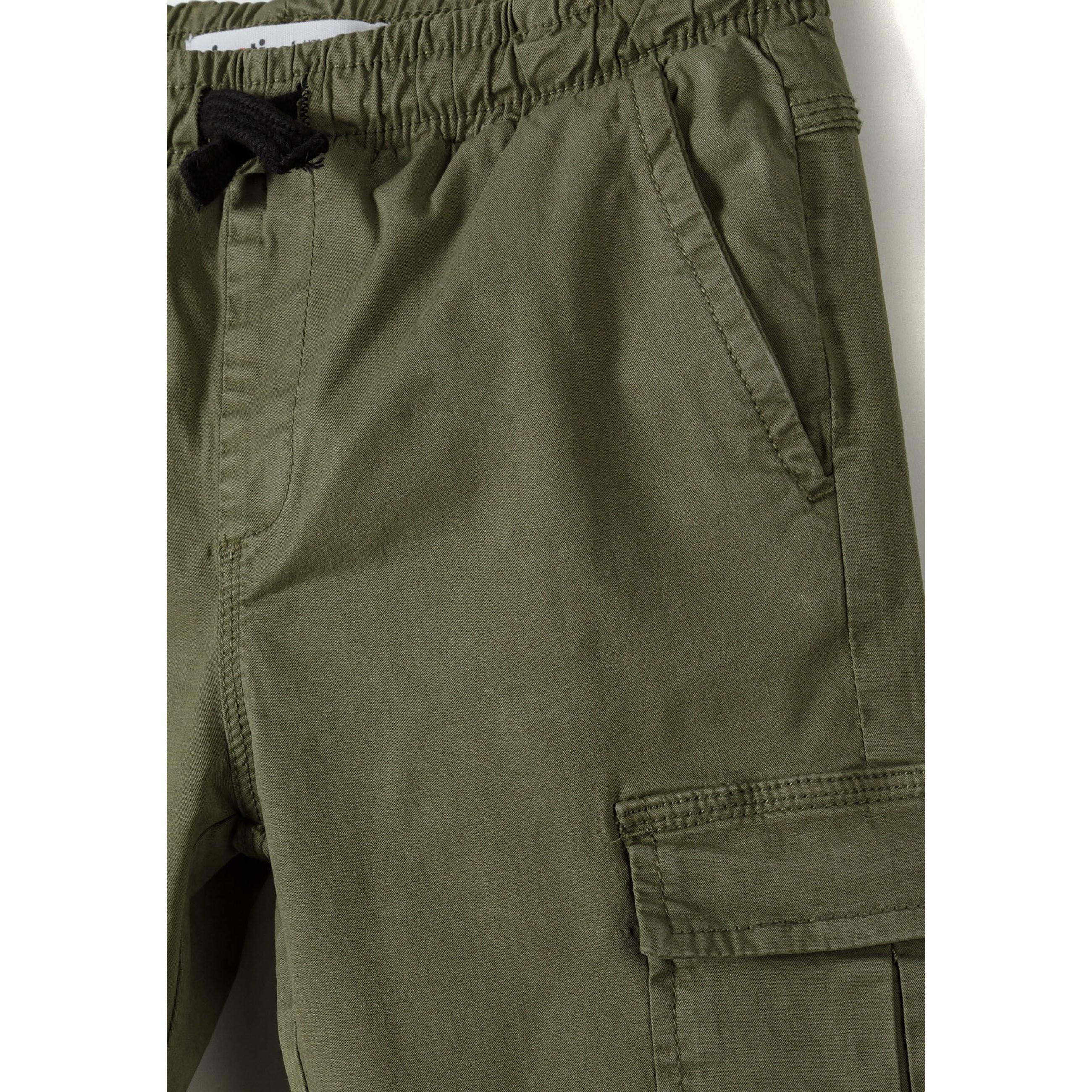 Close-up detail of khaki cargo trousers showing elasticated waistband with drawstring, side cargo pocket with flap closure, and fabric texture