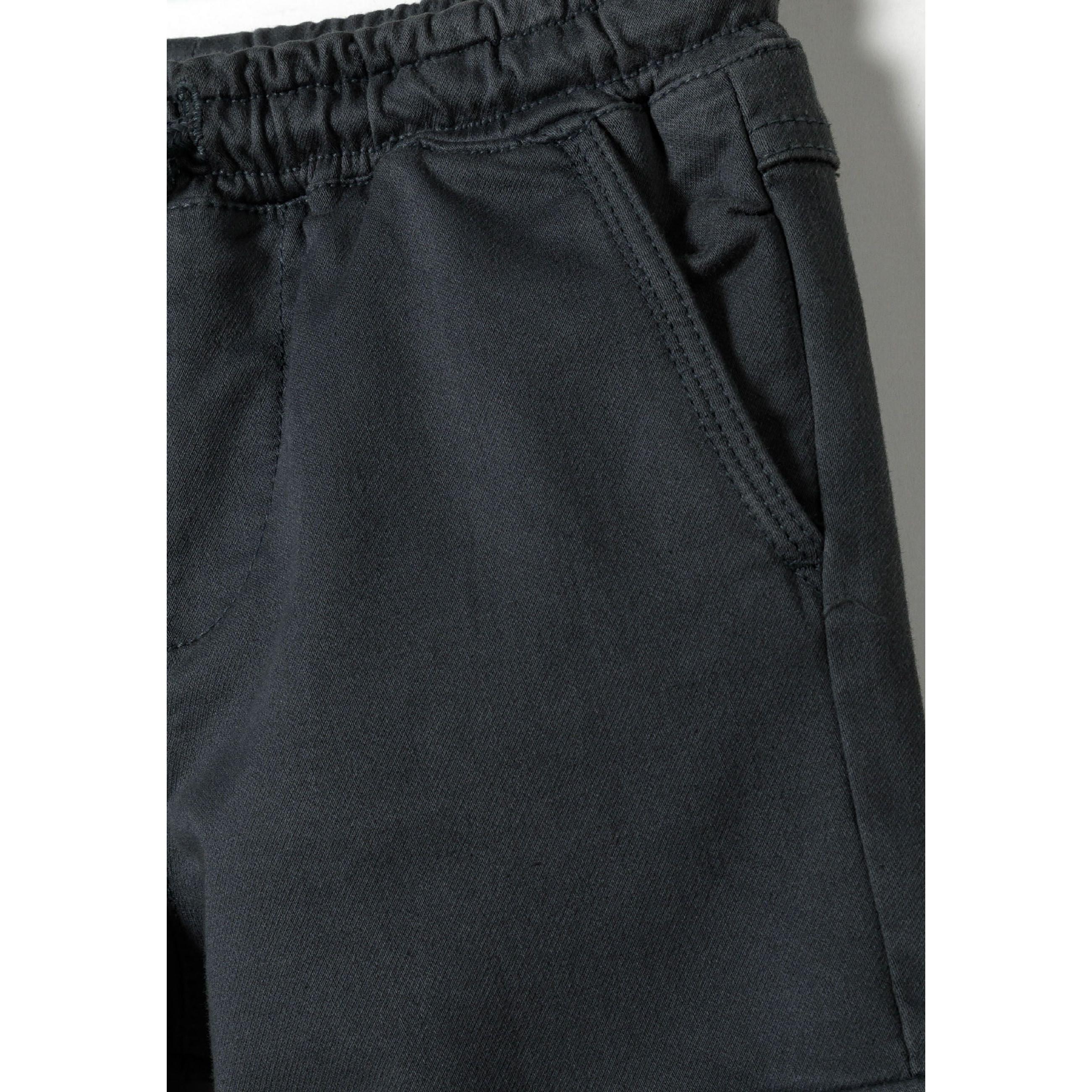 Close-up detail of charcoal cargo trousers showing fabric texture and elasticated waistband construction