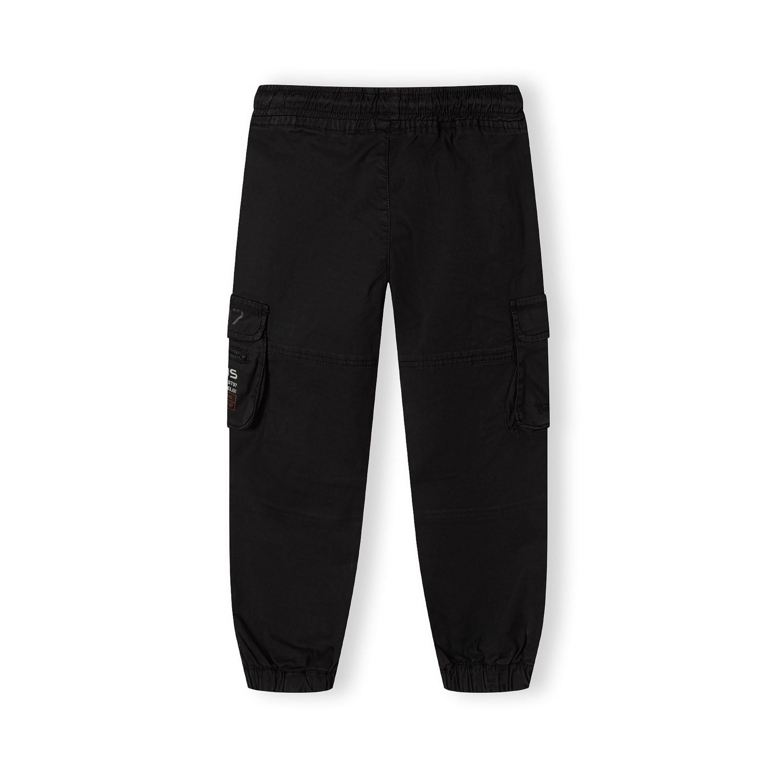 Black cargo trousers laid flat showing elastic waistband, side cargo pockets and tapered leg design