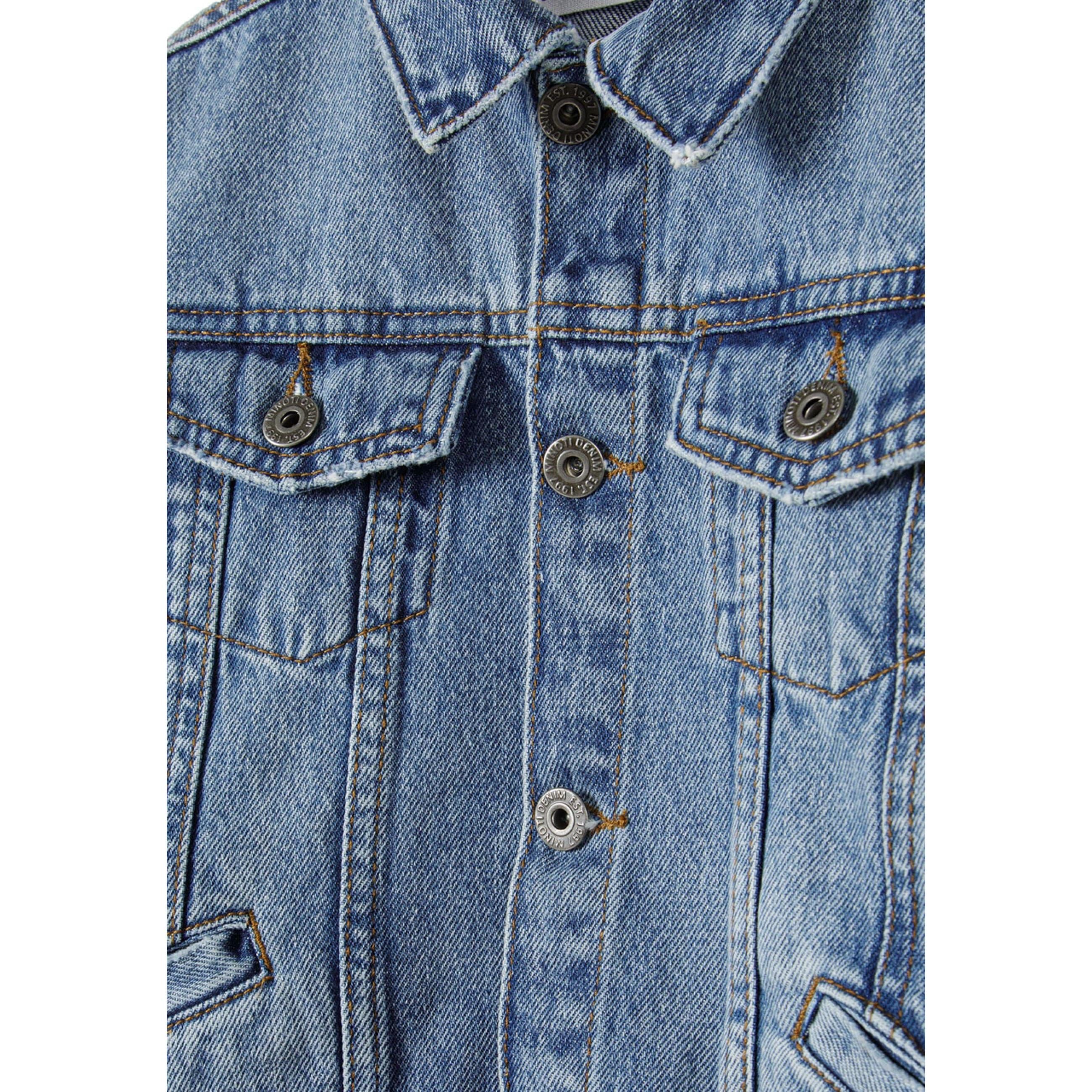 Close-up detail of navy denim jacket showing button closure, chest pockets with button tabs and classic denim texture and stitching
