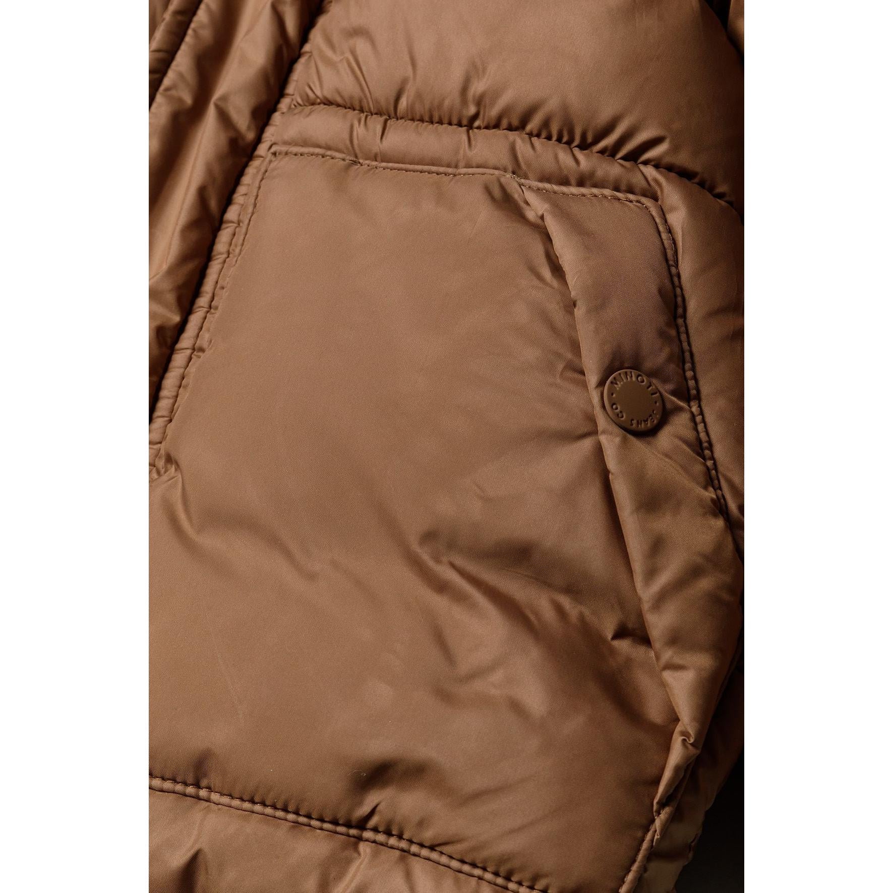 Close-up detail of brown padded jacket pocket with snap button closure and quilted fabric texture