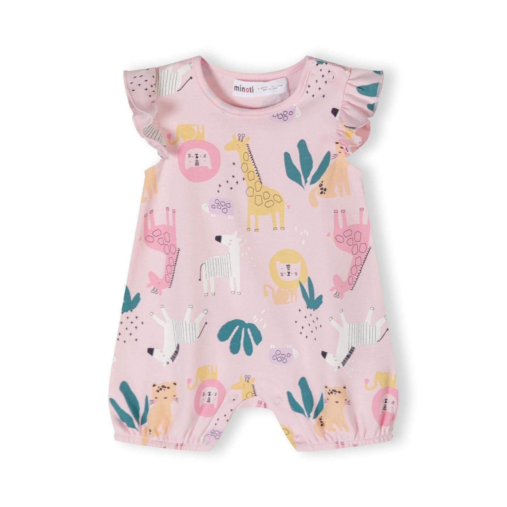 Close-up detail of pink romper showing safari animal print including yellow giraffe, pink lion face, teal leaves and geometric patterns on soft cotton fabric