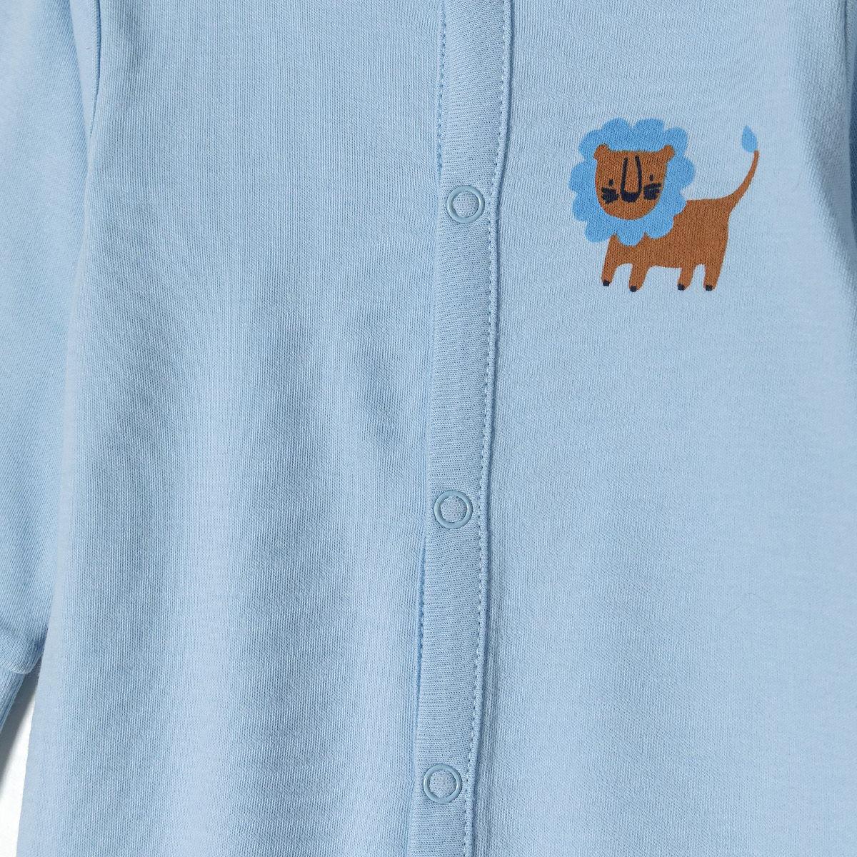 Close-up detail of light blue sleepsuit showing snap button closure and embroidered lion with blue mane design