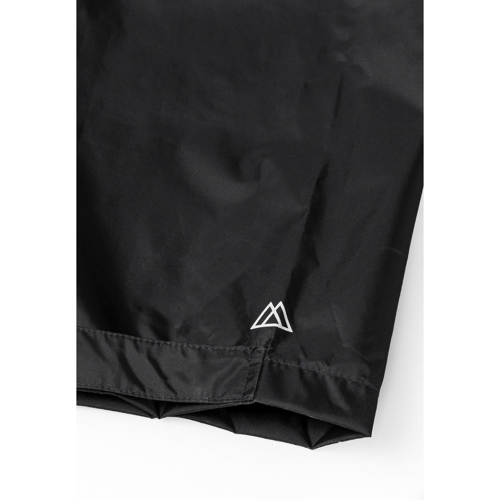 Close-up detail of black waterproof pants showing elastic waistband and taped seams