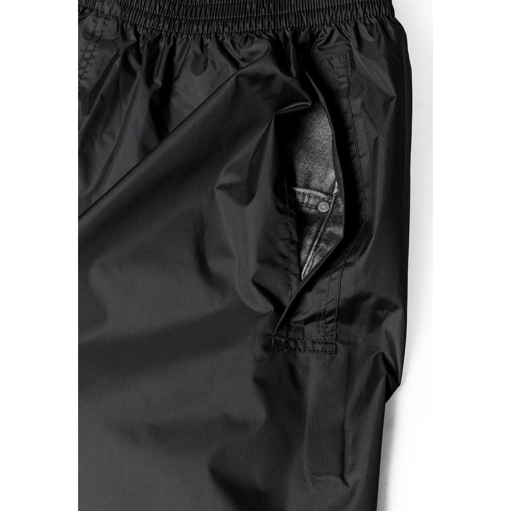 Close-up detail of black waterproof pants showing elastic waistband and taped seams
