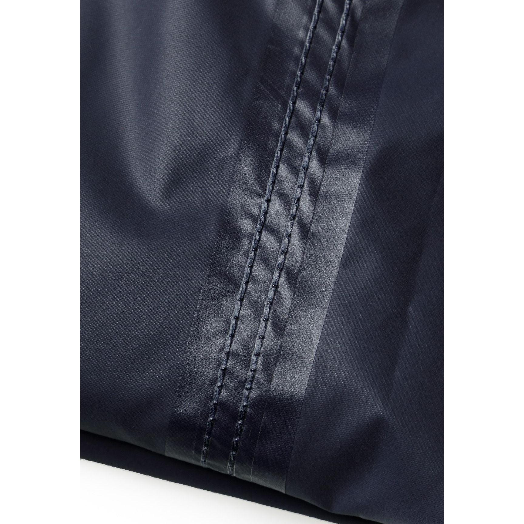 Detail shot of navy waterproof fabric showing reinforced seam stitching and weather-resistant construction