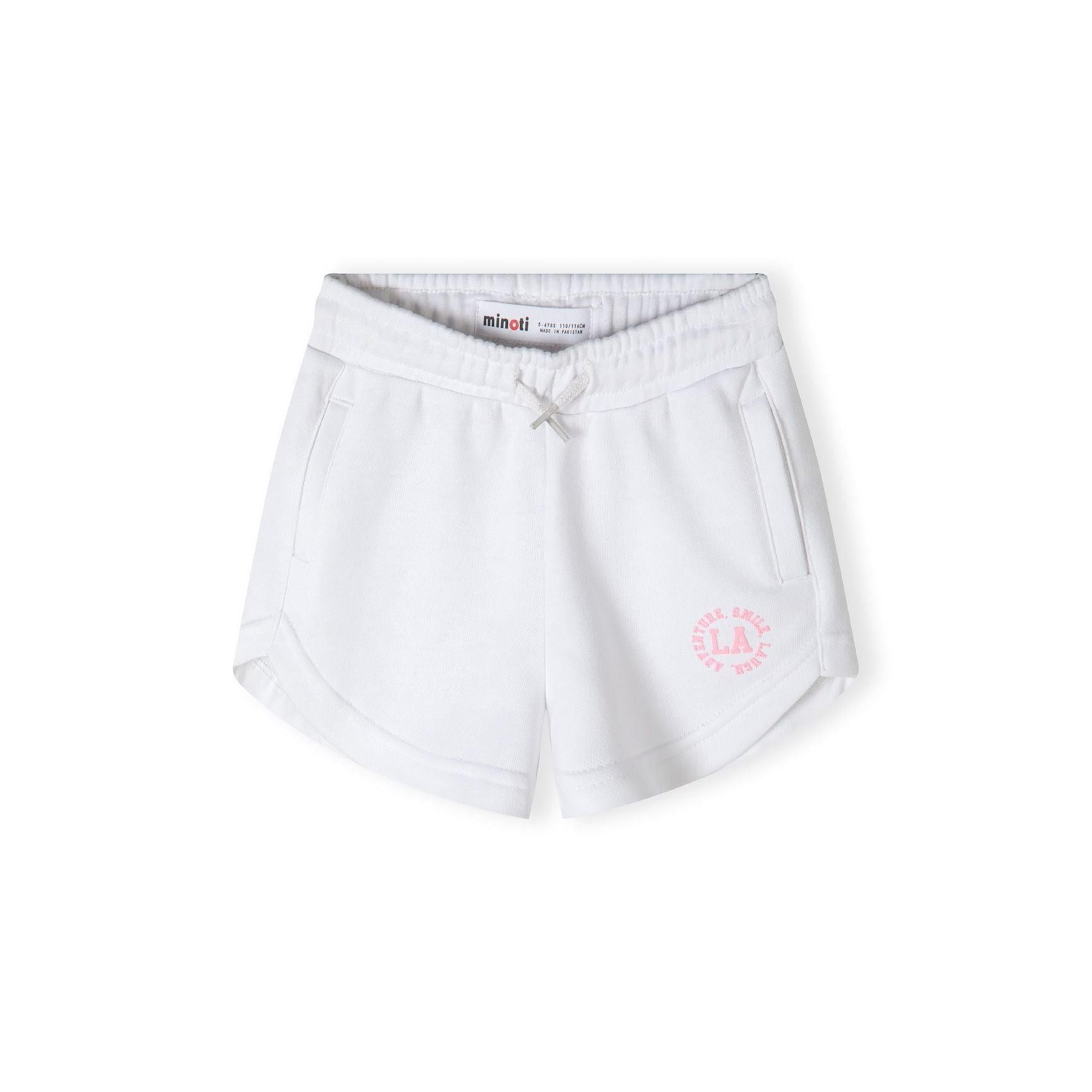 Close-up detail of white shorts showing pink circular L.A. logo with 'SMILE' text around the border