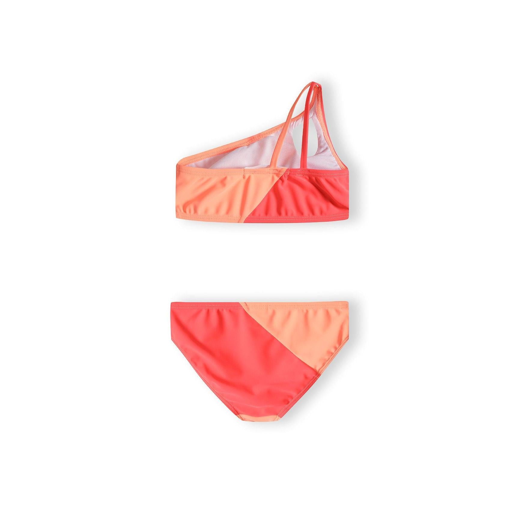 Close-up view of asymmetric bikini top showing one-shoulder design and colour-block pattern in apricot and coral on white background