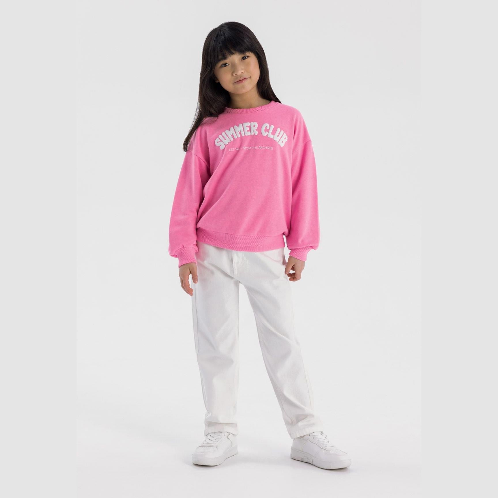 Girl wearing white twill mom fit trousers with pink sweatshirt, full body front view on white background