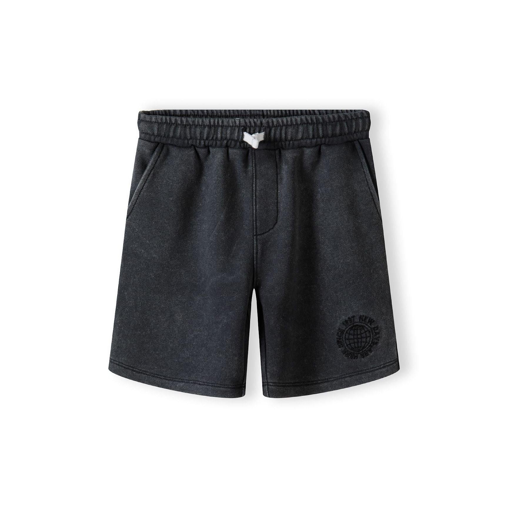 Close-up detail of washed grey fleece shorts showing elasticated waistband with white label and soft fabric texture