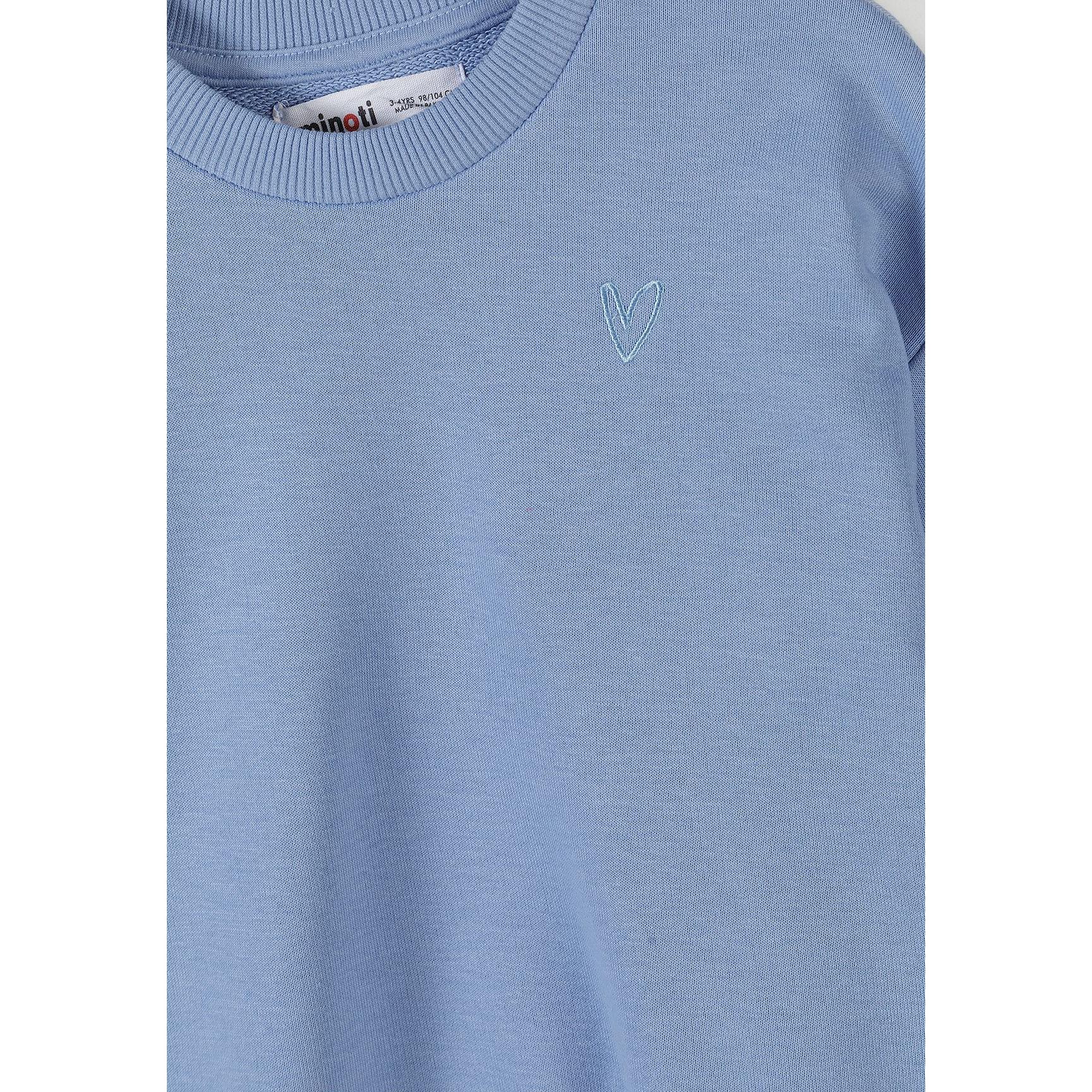 Close-up detail of blue crew neck sweatshirt showing Minoti label and small embroidered heart design on chest area