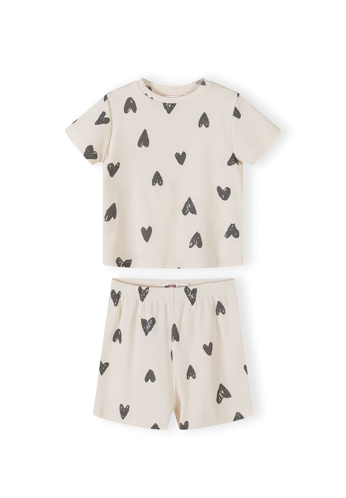 Single cream ribbed pyjama set with black hearts print showing short-sleeved top and matching shorts laid flat on white background