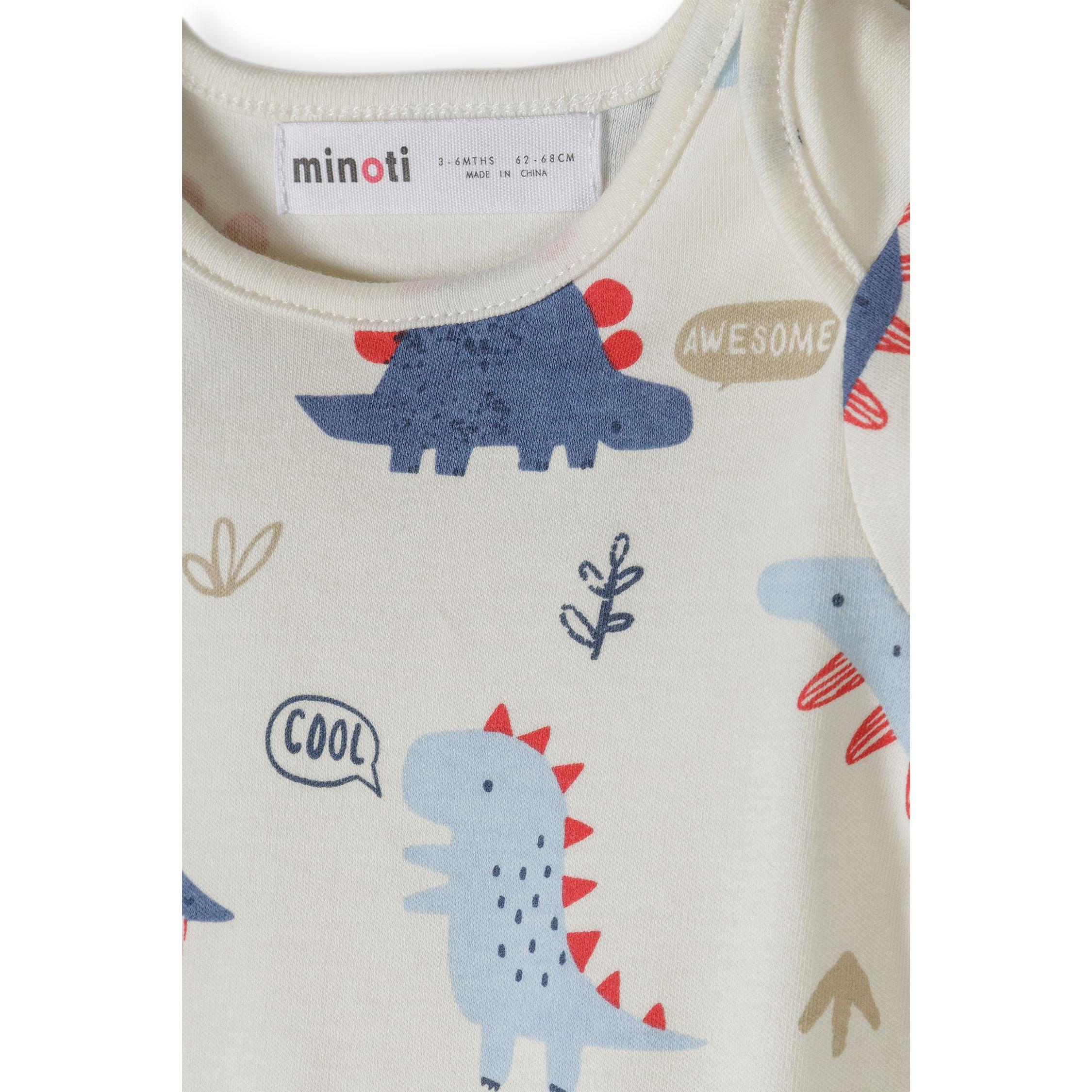 Close-up detail of cream bodysuit showing blue dinosaur with red spikes, speech bubbles saying 'AWESOME' and 'COOL', and Minoti size label