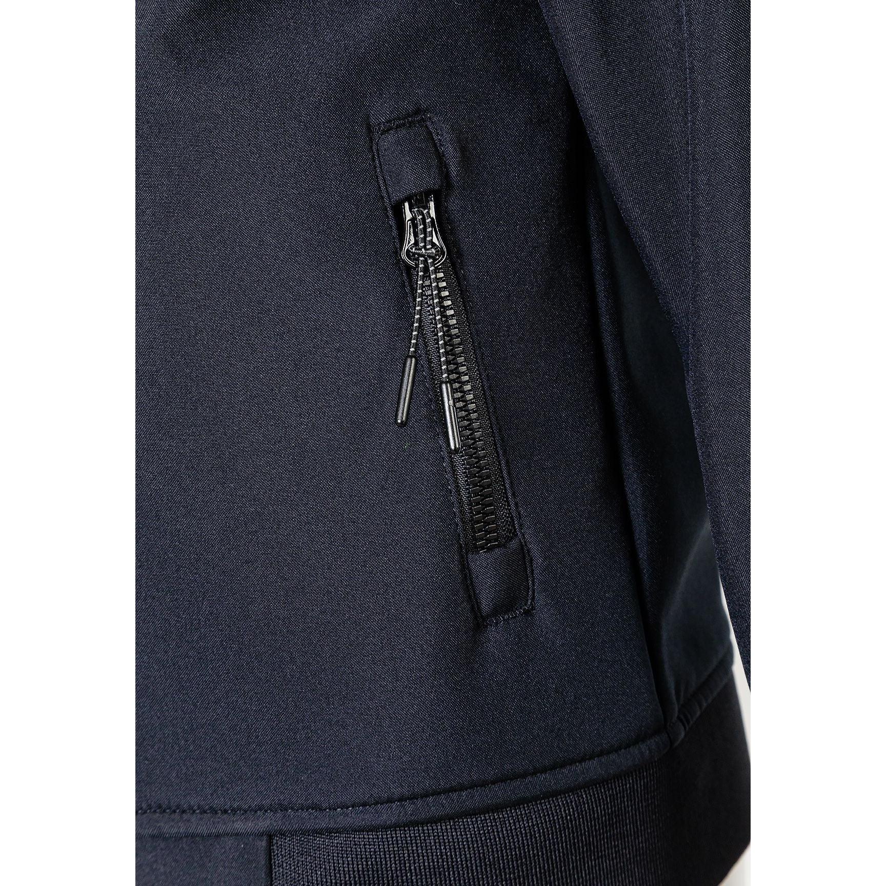 Close-up detail of black softshell jacket showing zippered side pocket with metal zipper pull and fabric texture