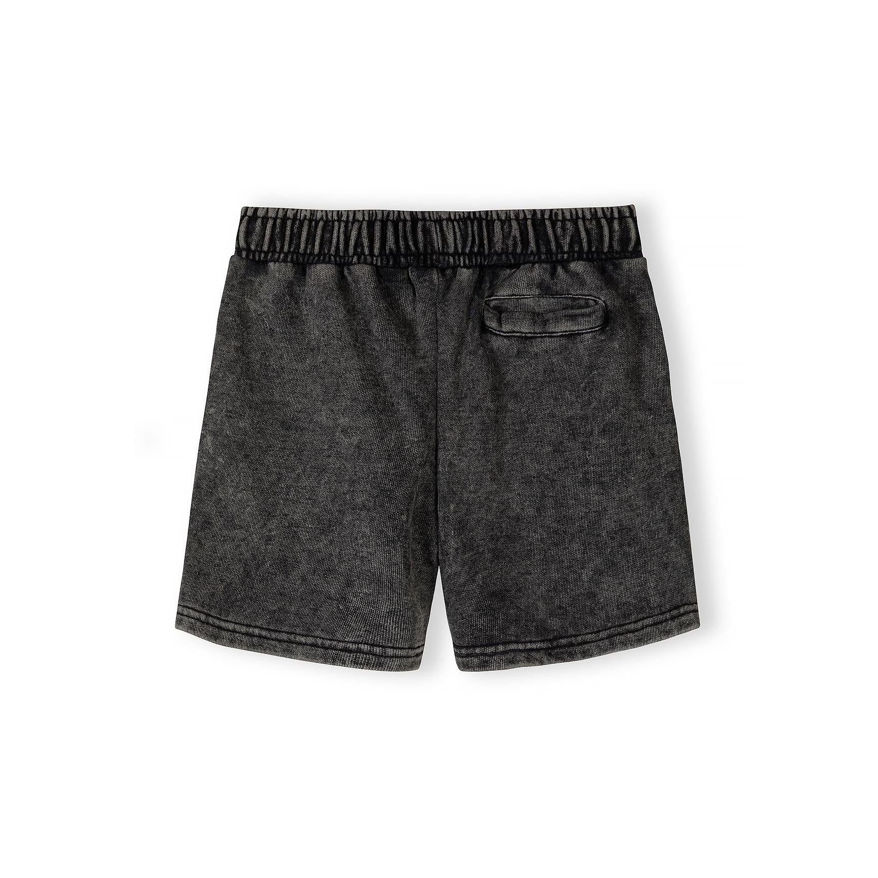 Close-up detail of grey acid wash fabric texture showing circular logo print and neckline construction