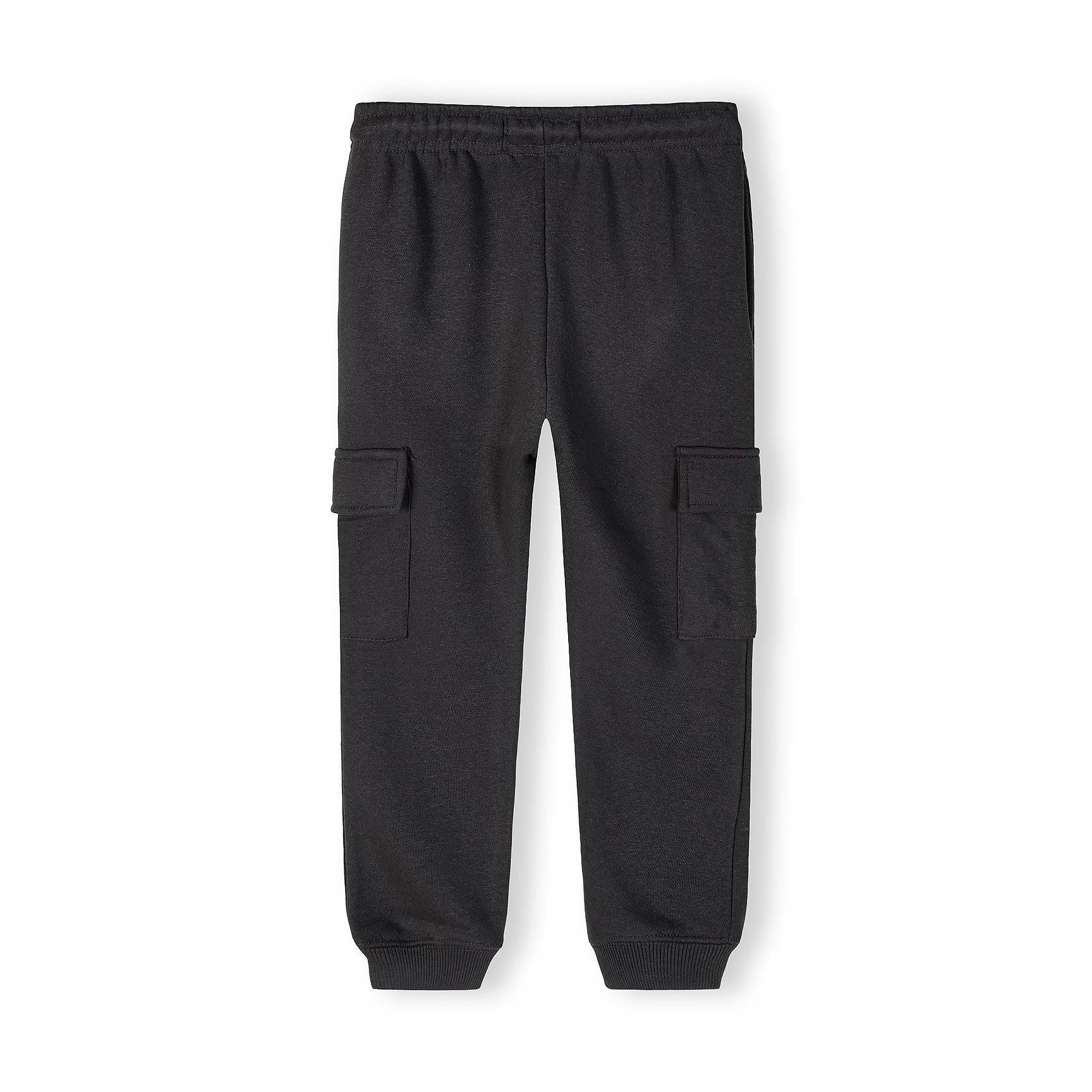 Black cargo joggers flat lay on white background showing functional side cargo pockets and elastic waistband detail