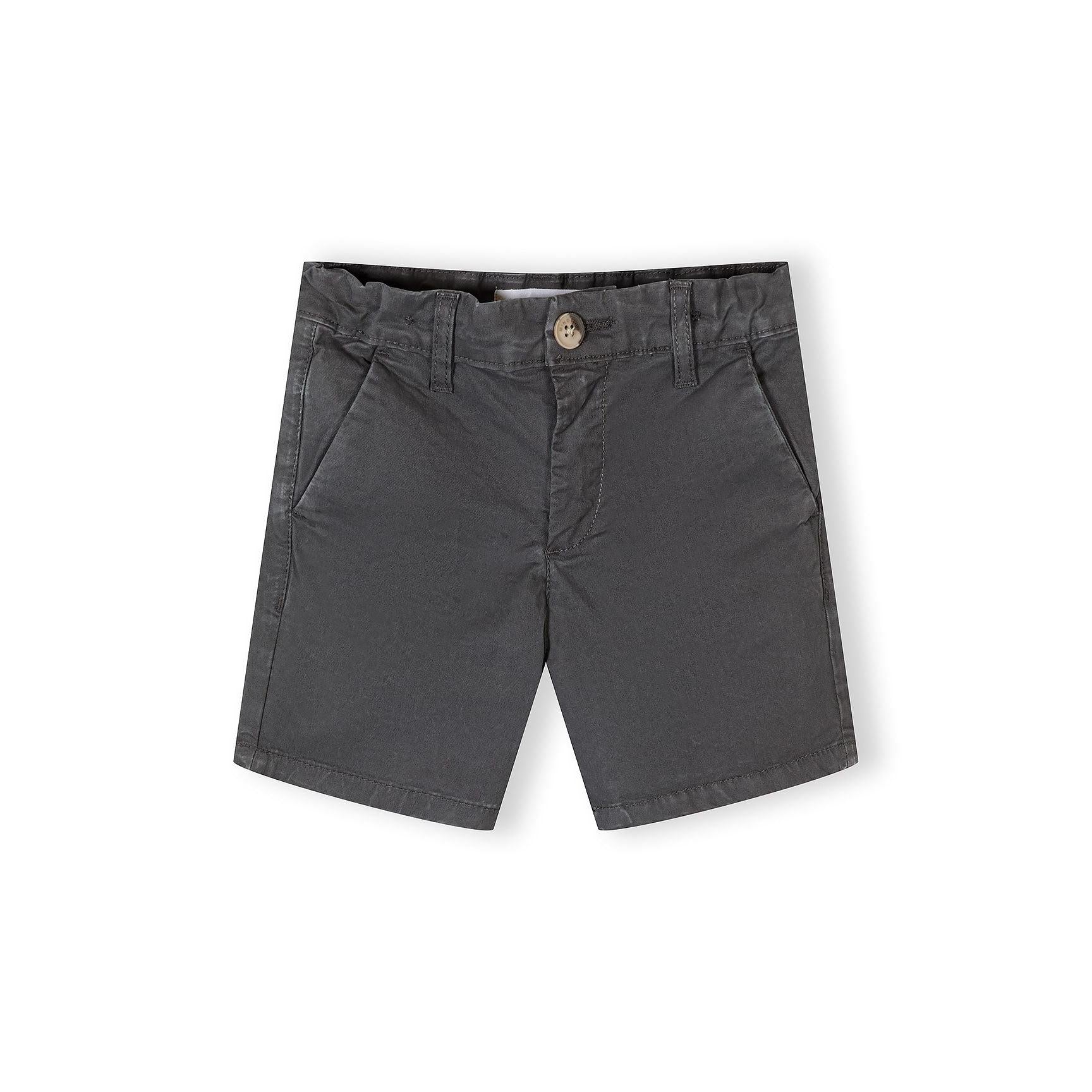 Close-up of sand brown chino shorts showing detailed construction with button waistband, side pockets, and quality stitching against white background