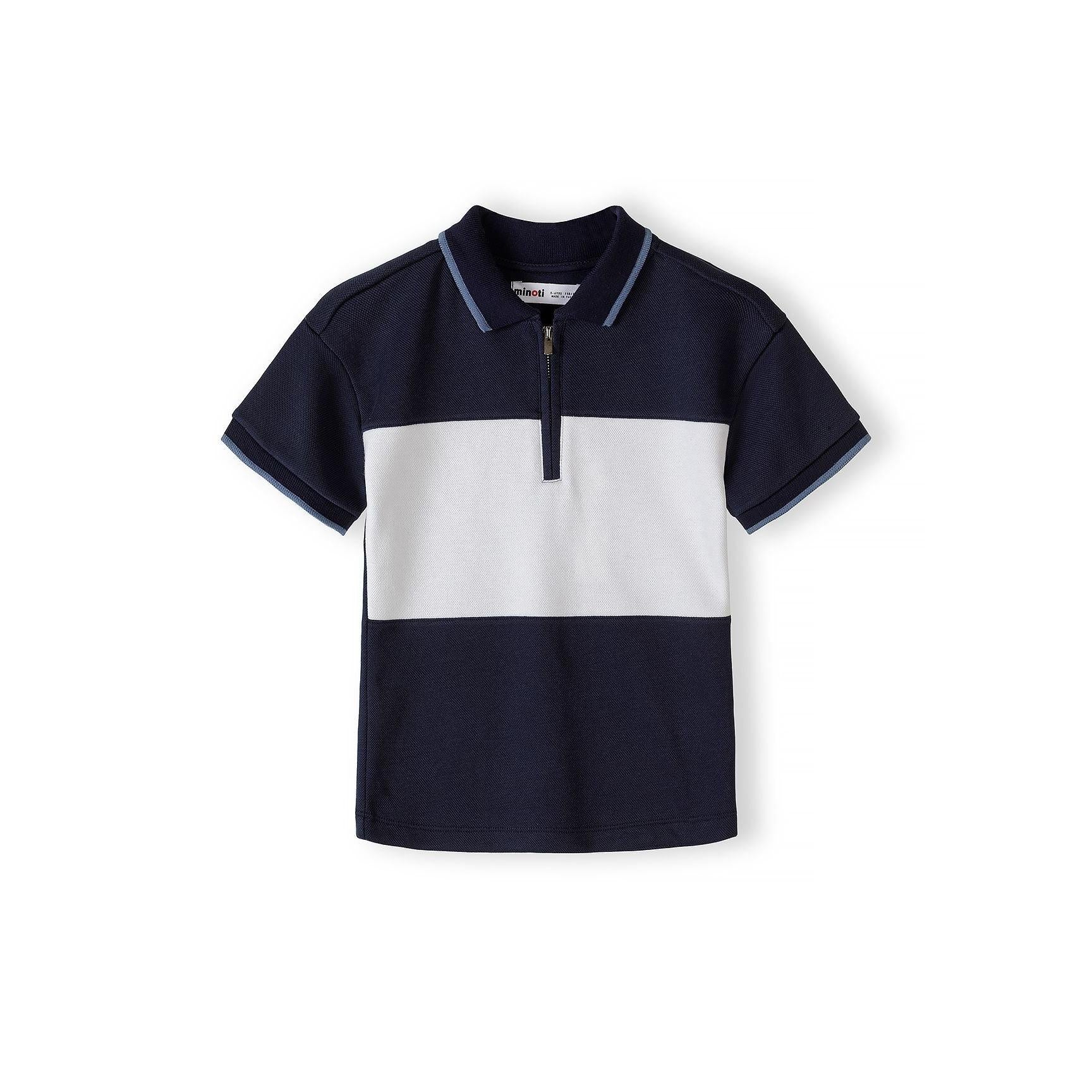 Close-up detail of Minoti label and zip collar on navy and white pique polo shirt showing textured fabric