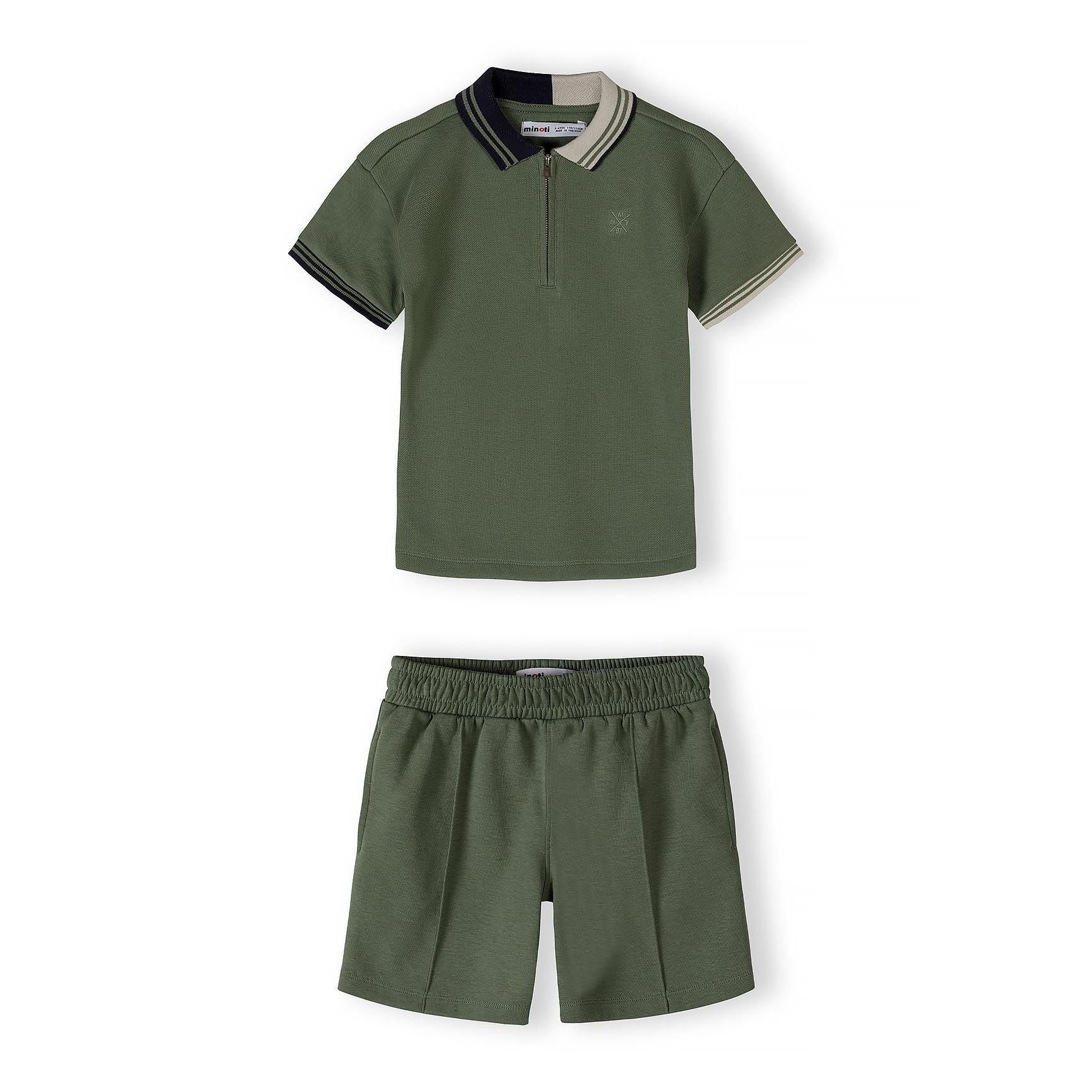 Close-up detail of teal polo shirt showing Minoti label, half-zip closure, contrast collar trim and embroidered star logo