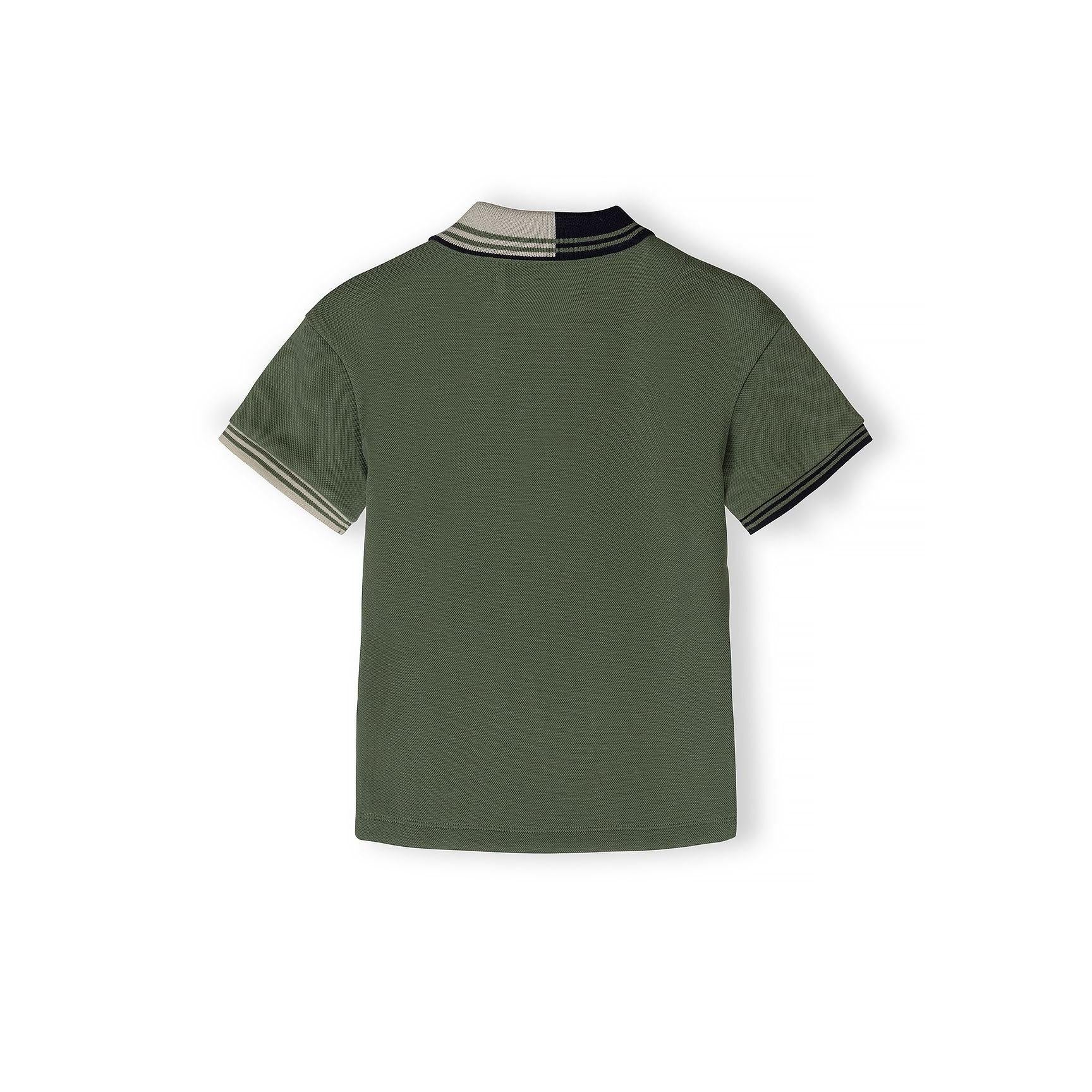 Close-up detail of teal polo shirt showing Minoti label, half-zip closure, contrast collar trim and embroidered star logo