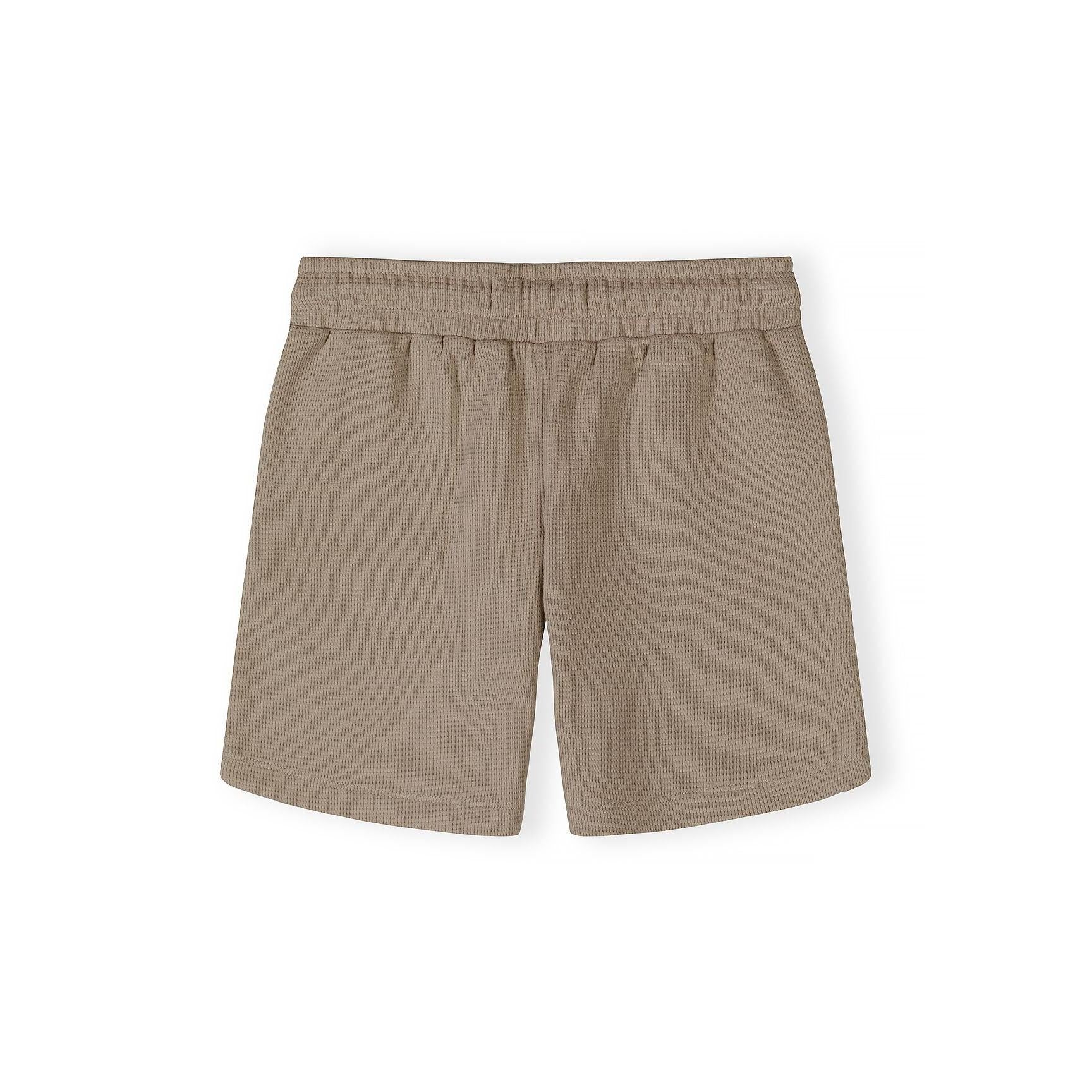 Close-up detail of taupe waffle cotton shirt showing Minoti label, button placket and textured fabric weave