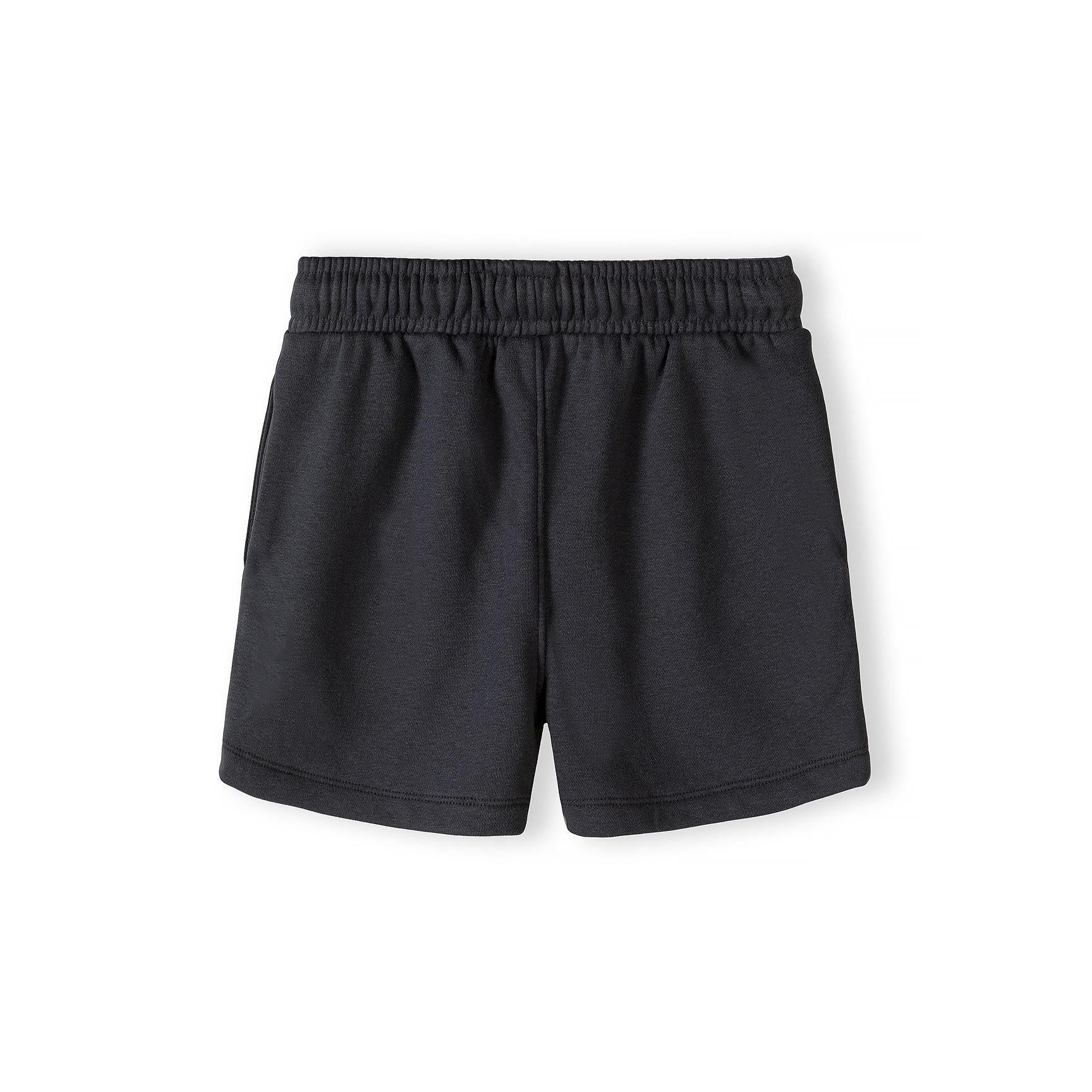 Close-up detail of urban collection patch on grey t-shirt featuring geometric cube logo and text