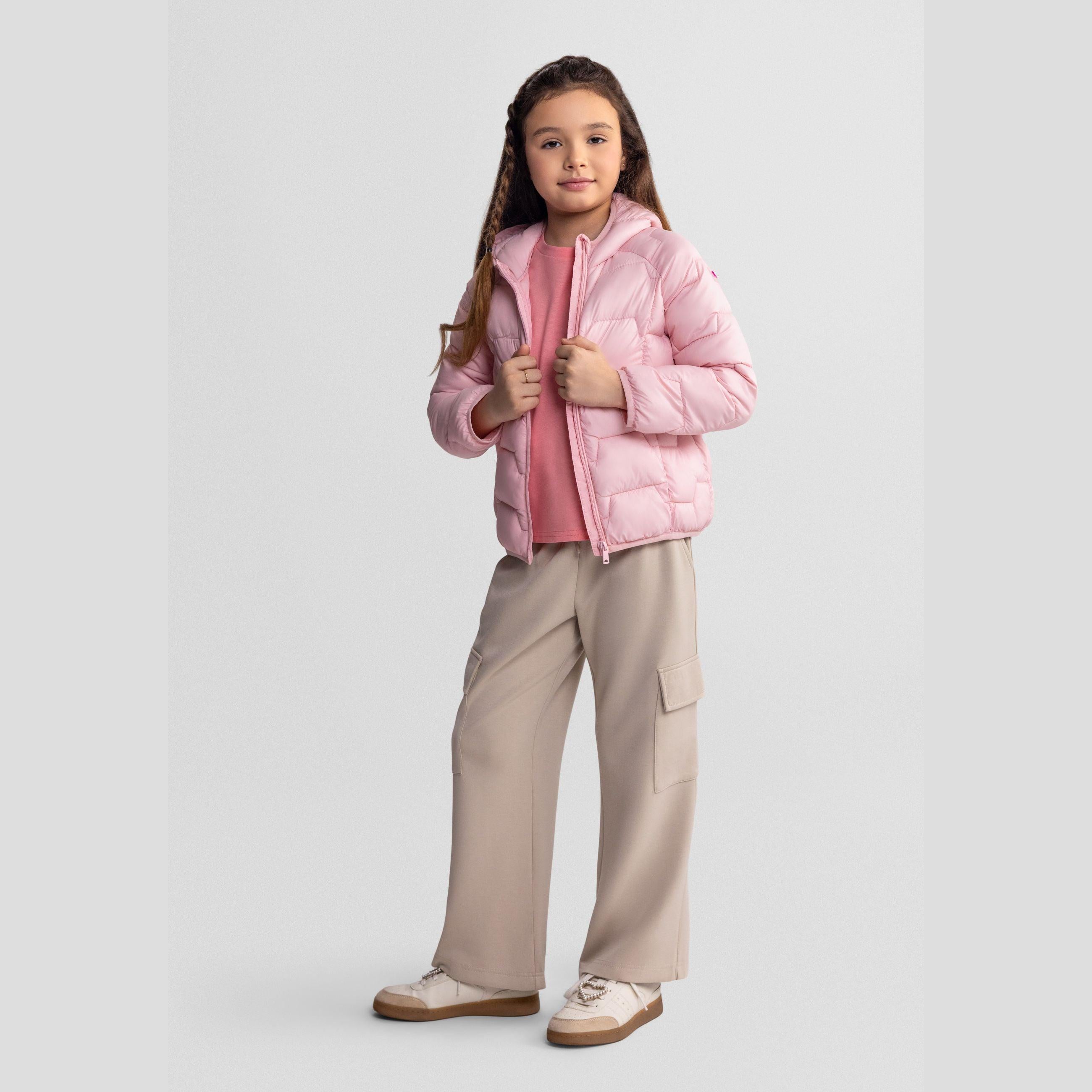 Same girl looking down wearing the pink quilted jacket with hood, showing full outfit styling with beige wide-leg trousers and white trainers