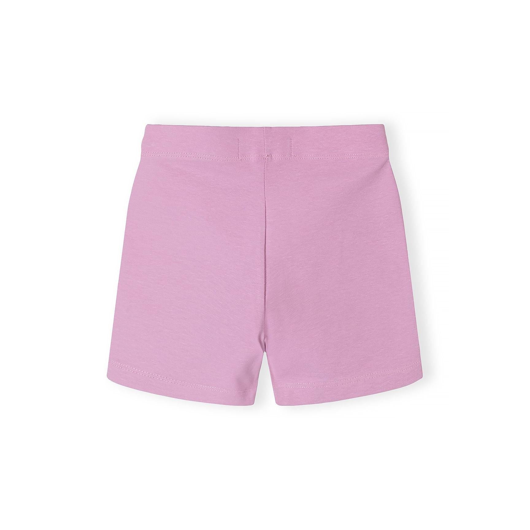 Close-up detail of pink cycle shorts with colorful heart print pattern showing yellow, mint green, and pink hearts on lilac background