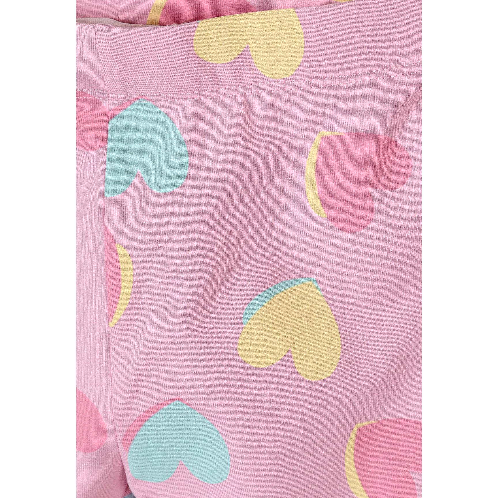 Close-up detail of pink cycle shorts with colorful heart print pattern showing yellow, mint green, and pink hearts on lilac background