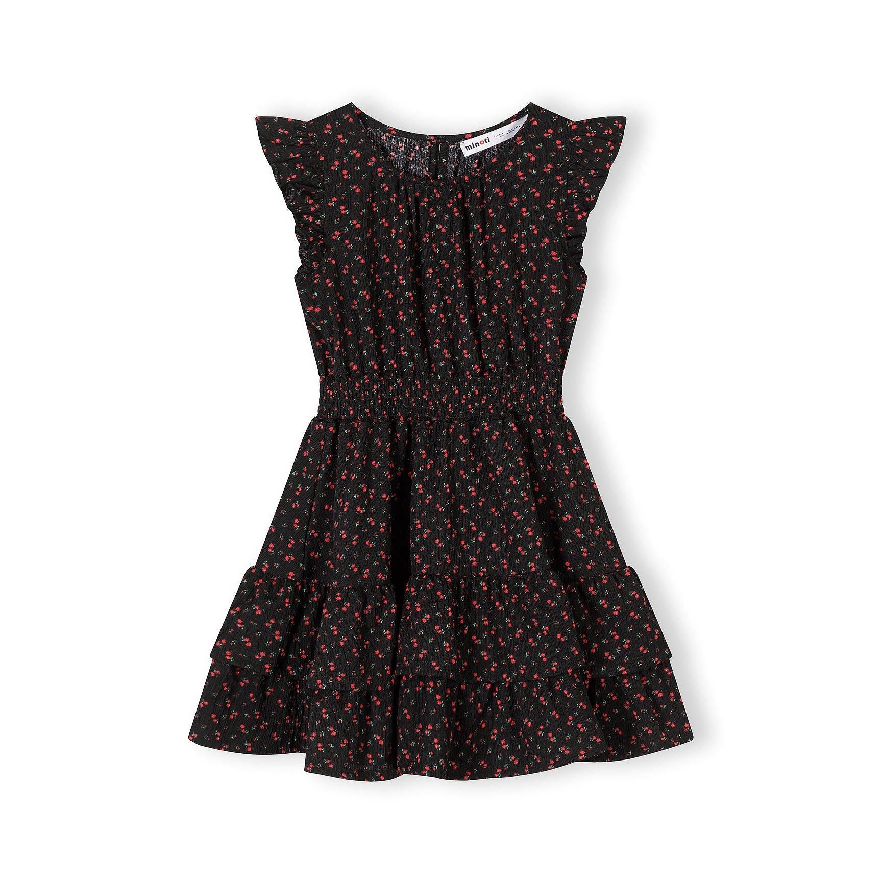 Flat lay view of black A-line dress with small red floral pattern and frill sleeves on white background showing full garment details