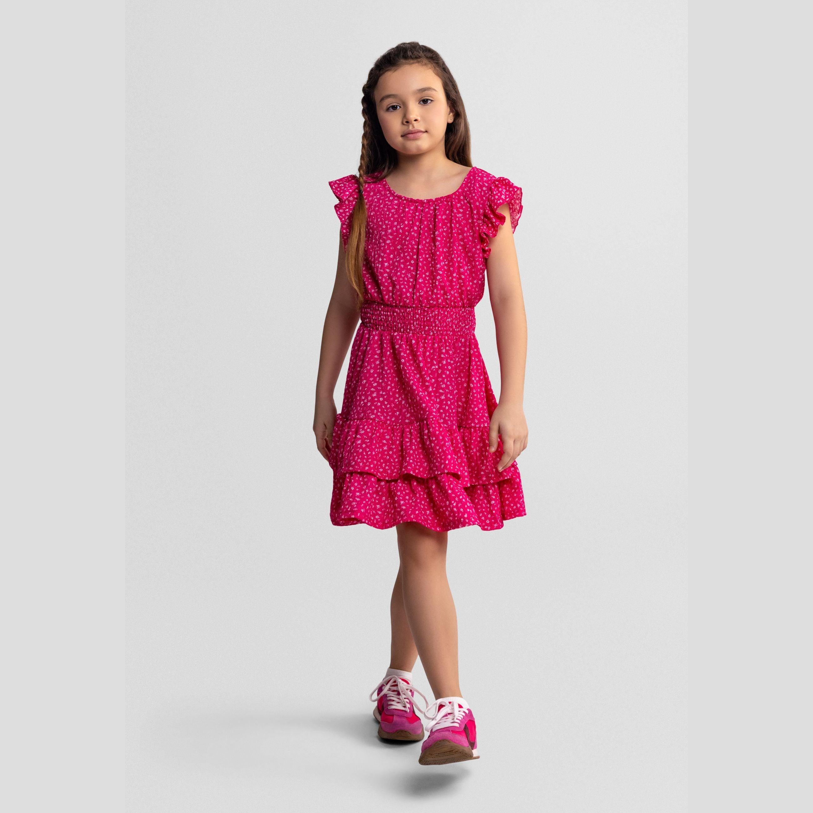 Pink floral dress laid flat showing frill sleeves, elasticated waist, tiered skirt design and white floral print pattern on pink fabric