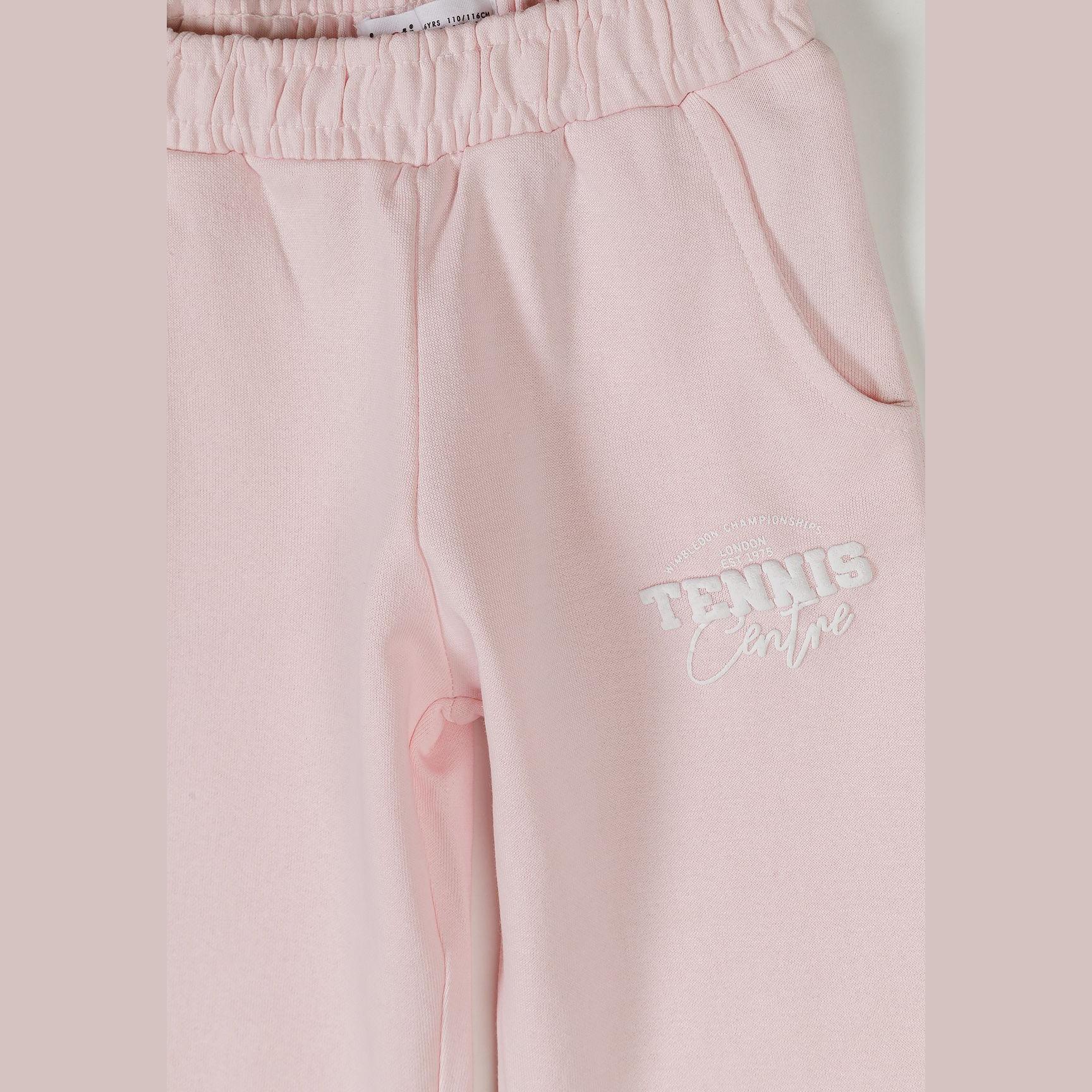 Close-up detail of light pink joggers showing elasticated waistband, side pocket and Tennis Camps print on leg