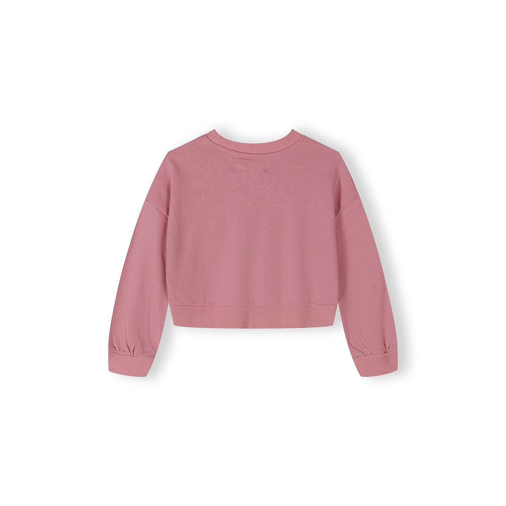 Close-up view of pink wide-leg joggers with elastic waistband and West Village USA New York print detail on white background